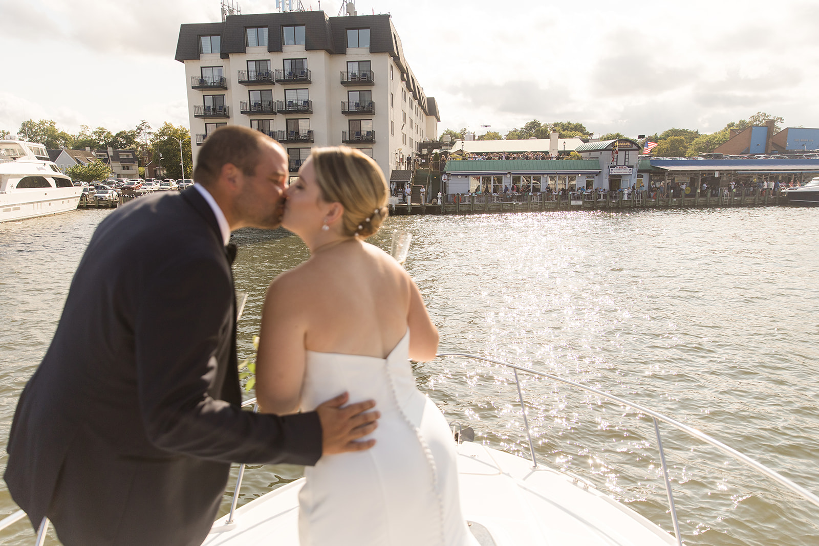 bride and groom kissing on bow of boat