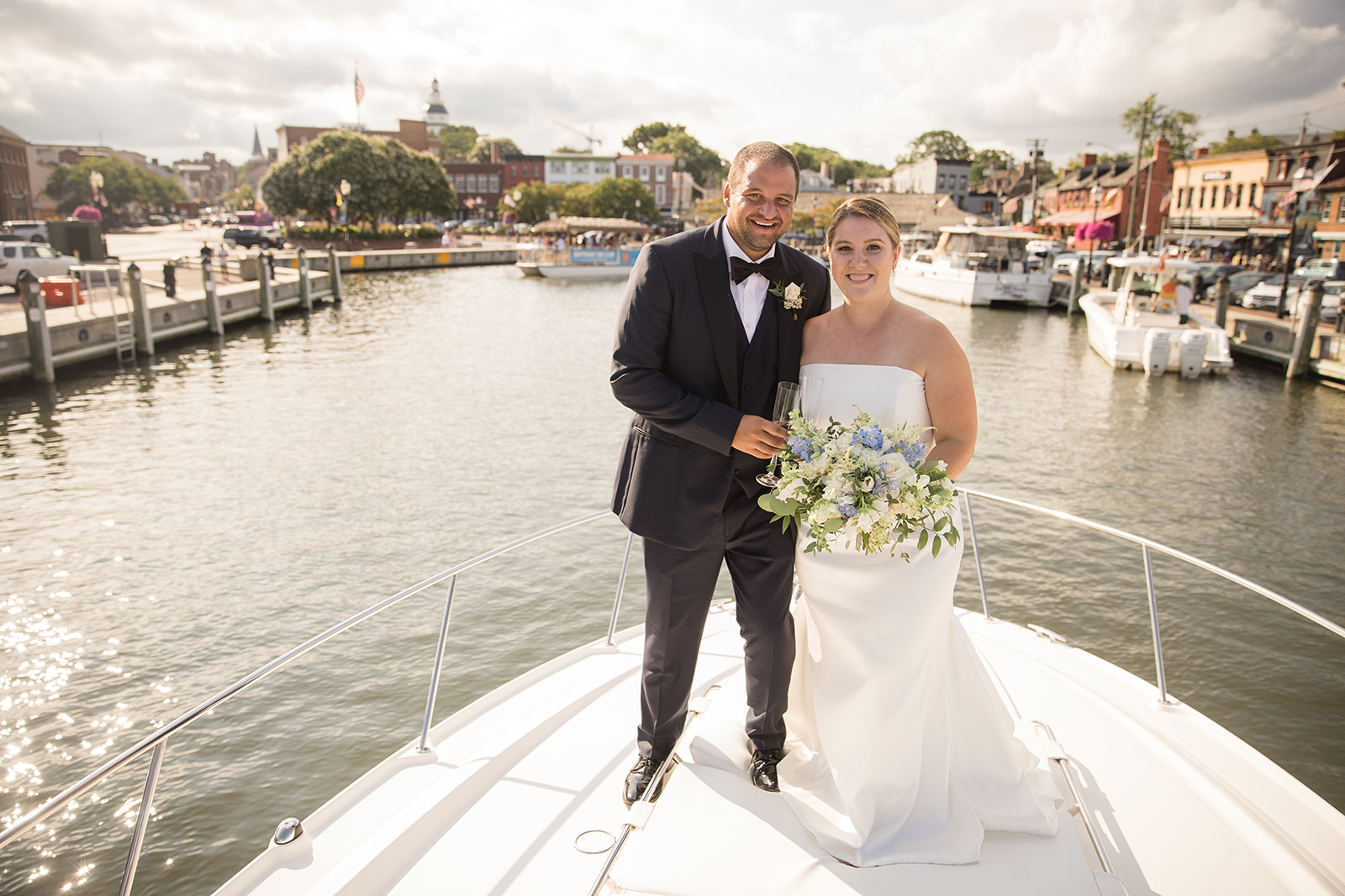 bride and groom on bow of boat