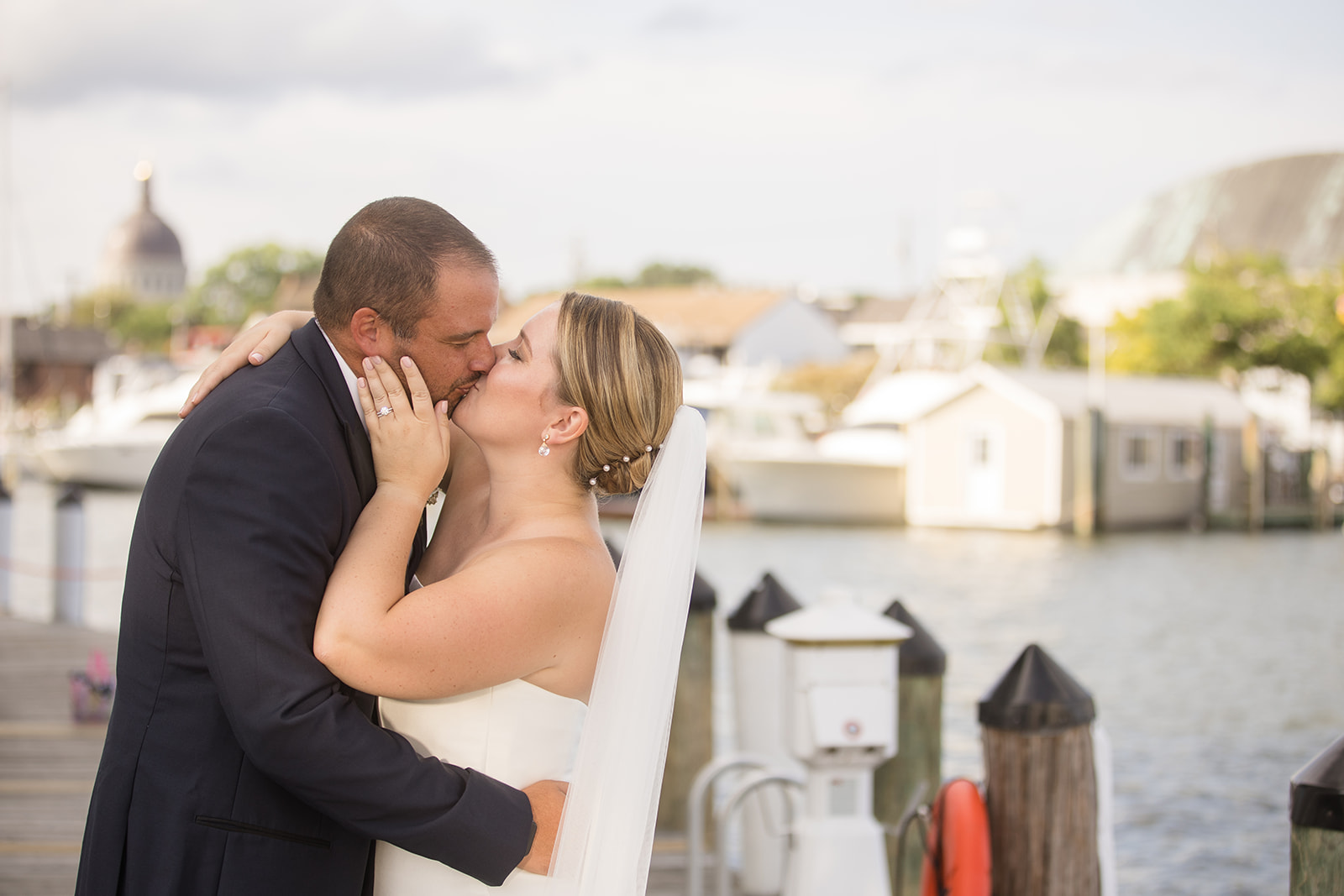 bride and groom kiss on annapolis docks