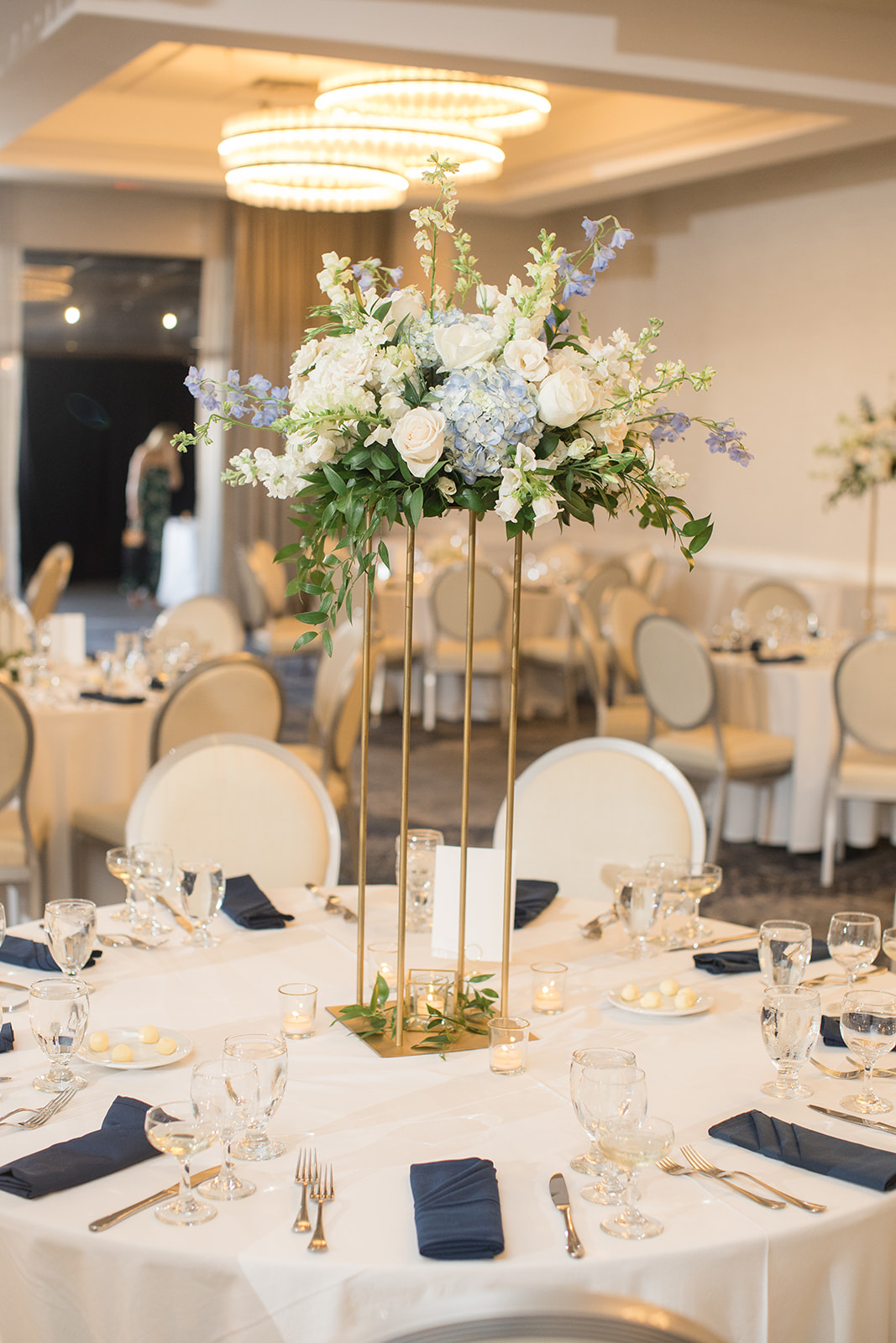 reception tables with blue napkins and high centerpieces