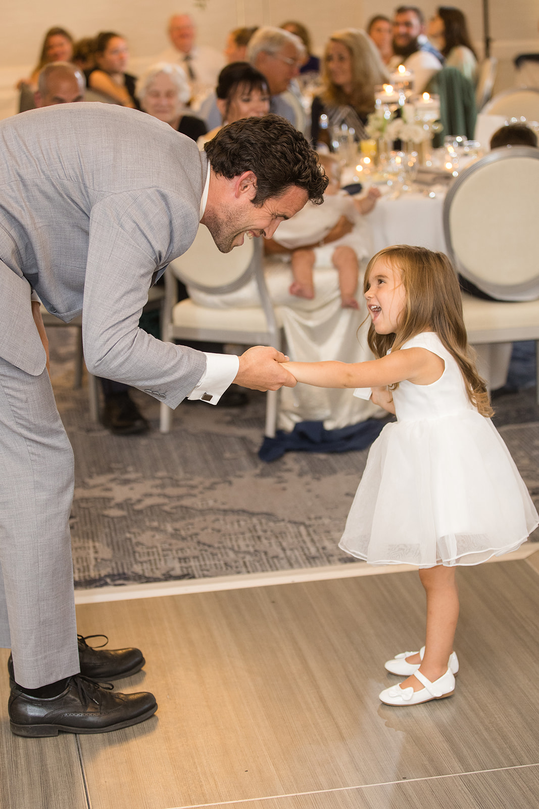 guest and flower girl shake hands on dance floor