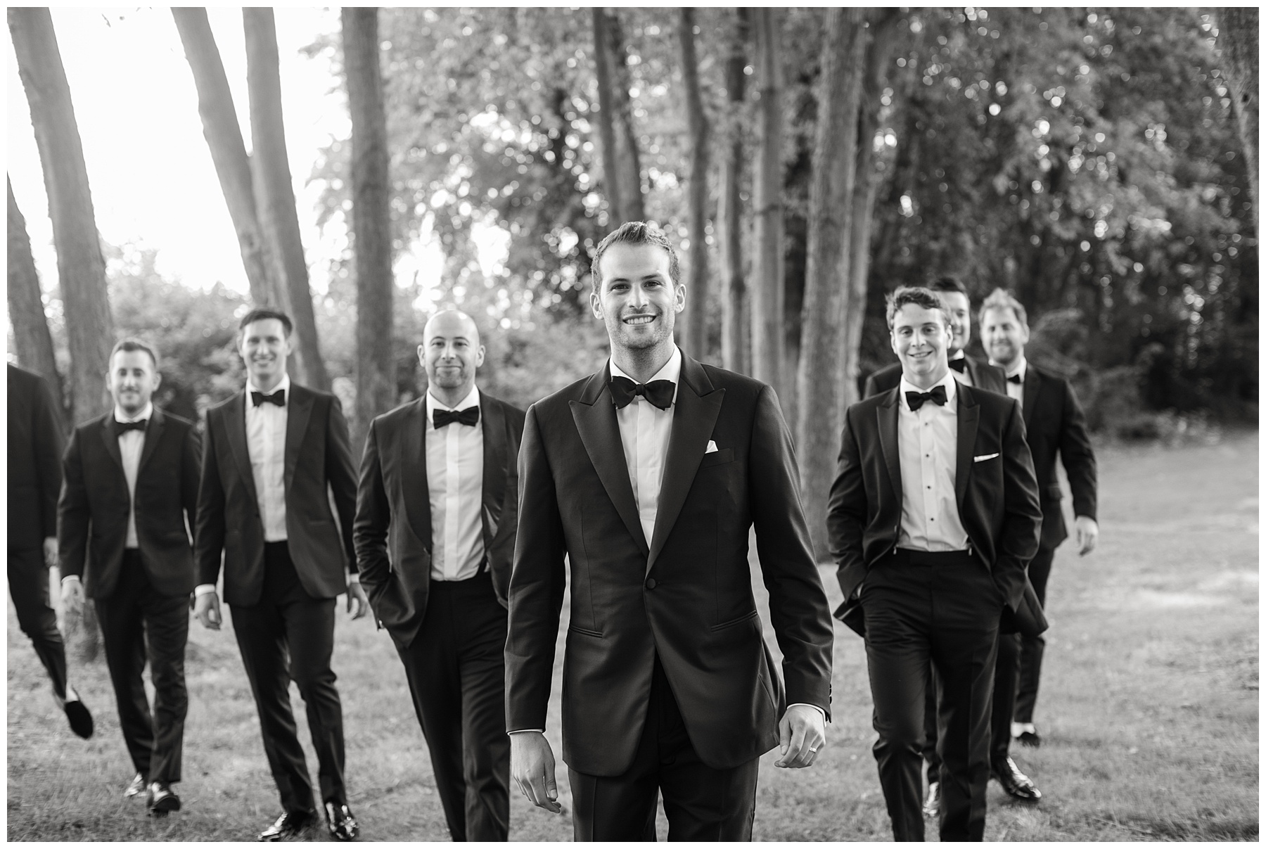 groom and groomsmen walking in tuxes