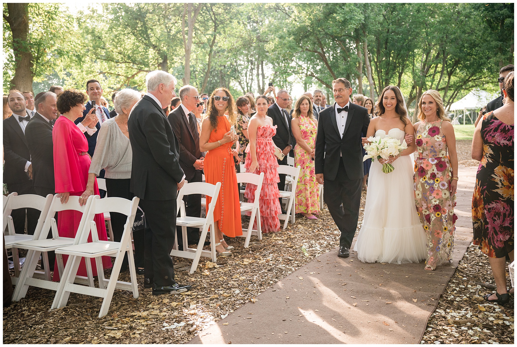 bride coming down aisle with parents outdoor wedding ceremony