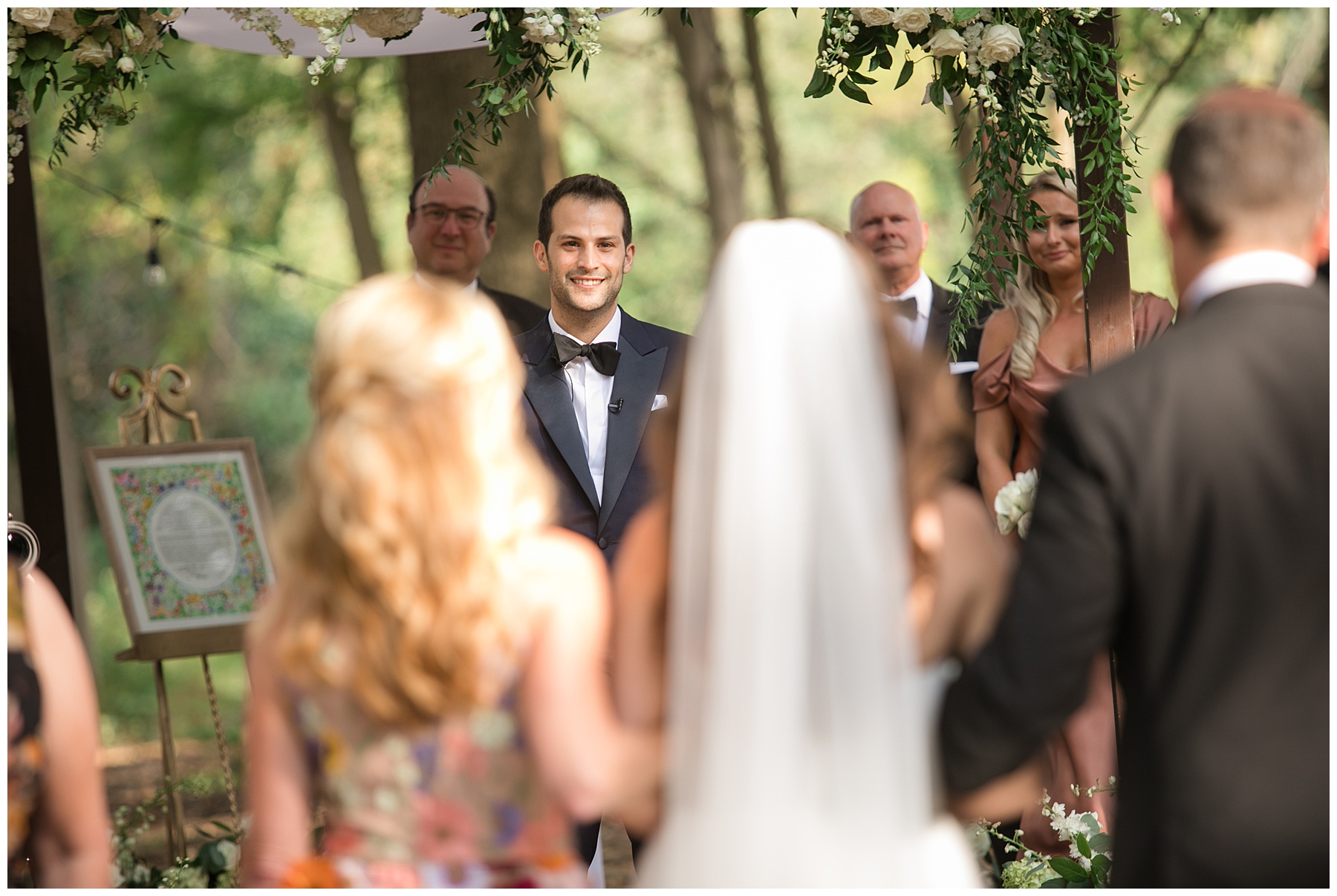 bride coming down aisle with parents outdoor wedding ceremony groom's face