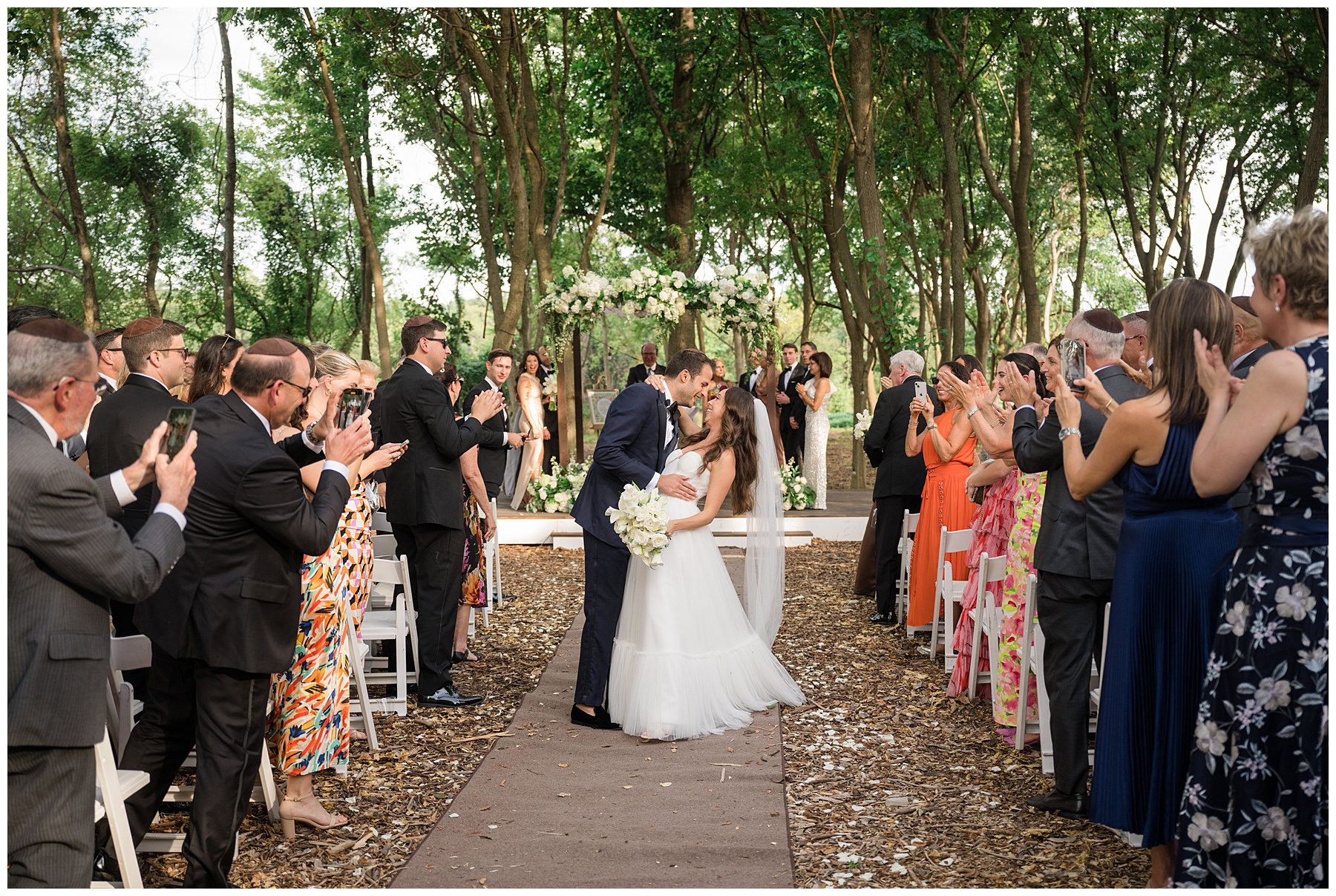 bride and groom kiss coming down aisle