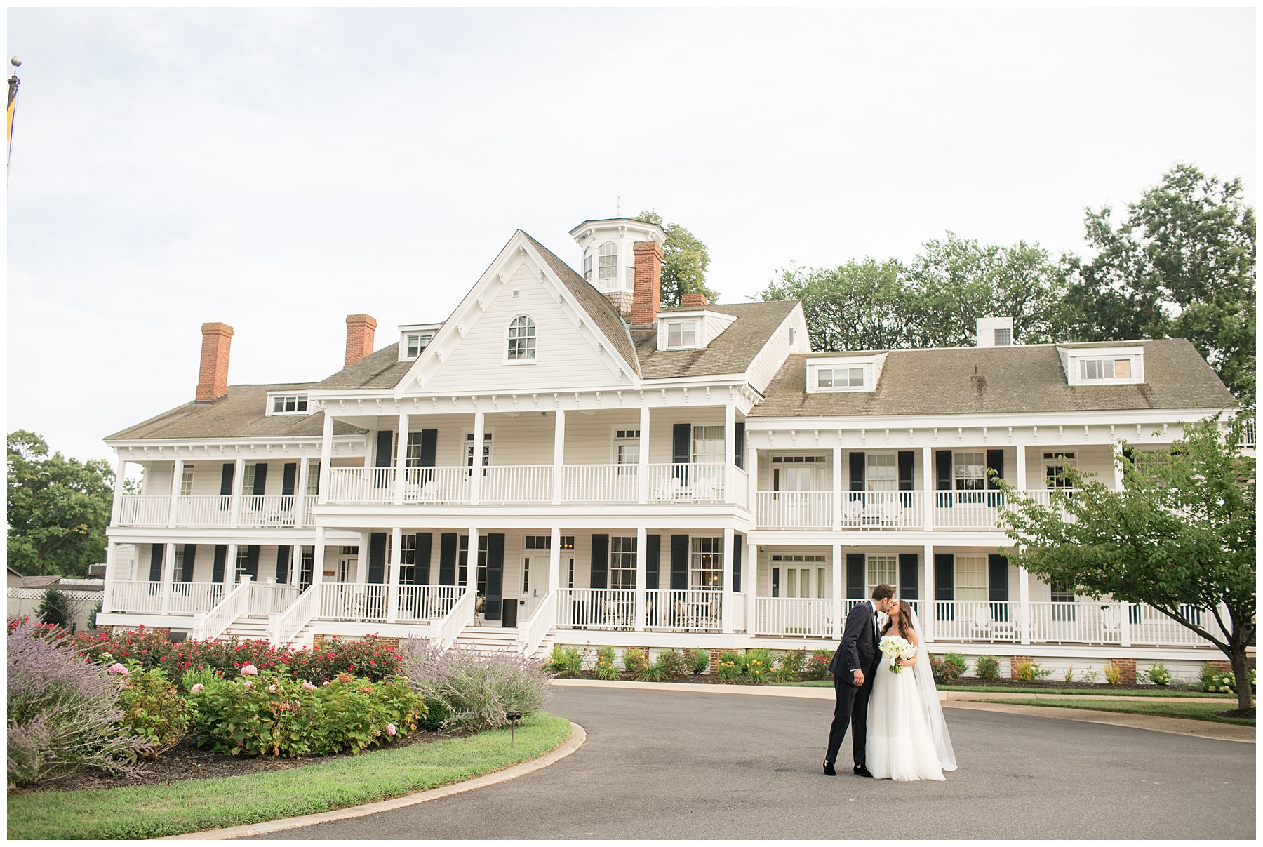 bride and groom kiss wide shot in front of kent island resort