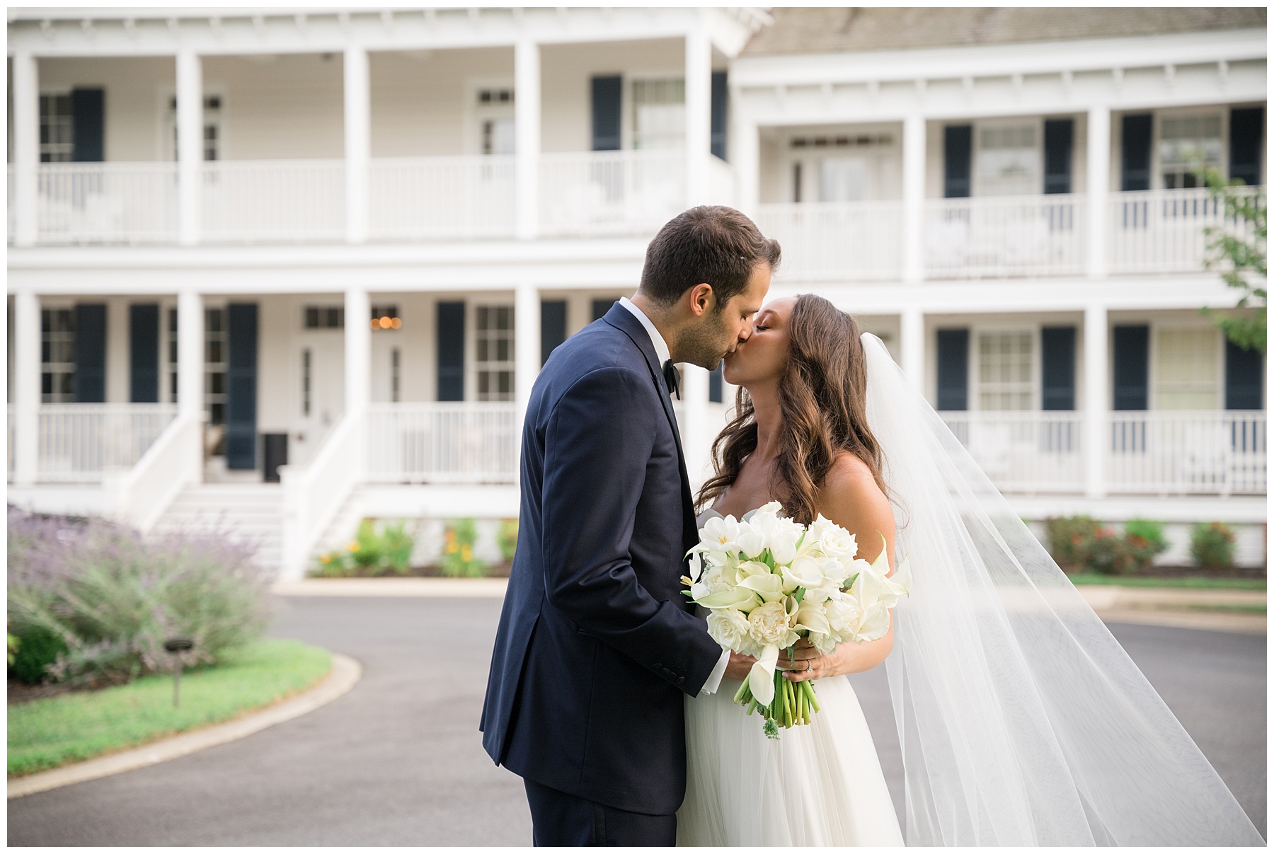 bride and groom kiss in front of venue resort