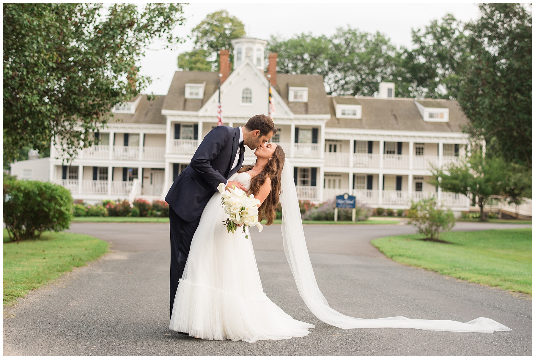 bride and groom kiss in front of kent island resort