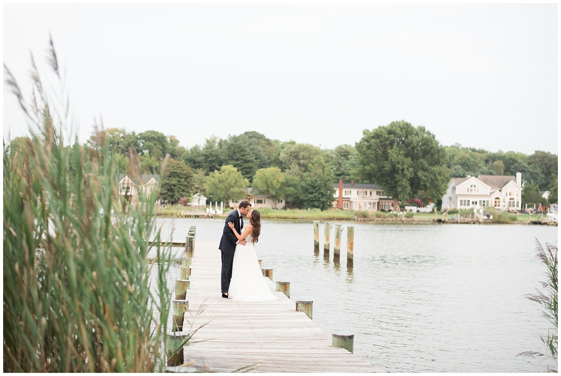 bride and groom kissing on pier in kent island