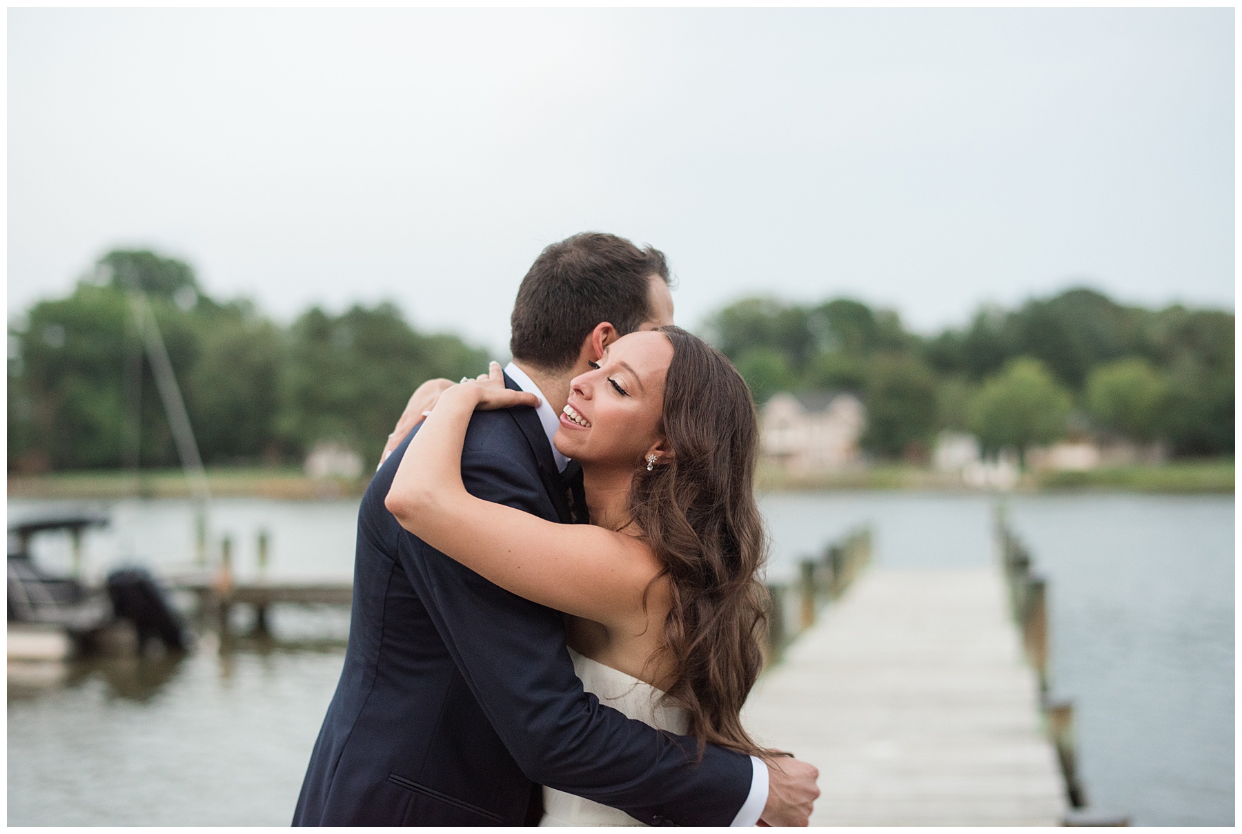 bride and groom embracing on pier in kent island