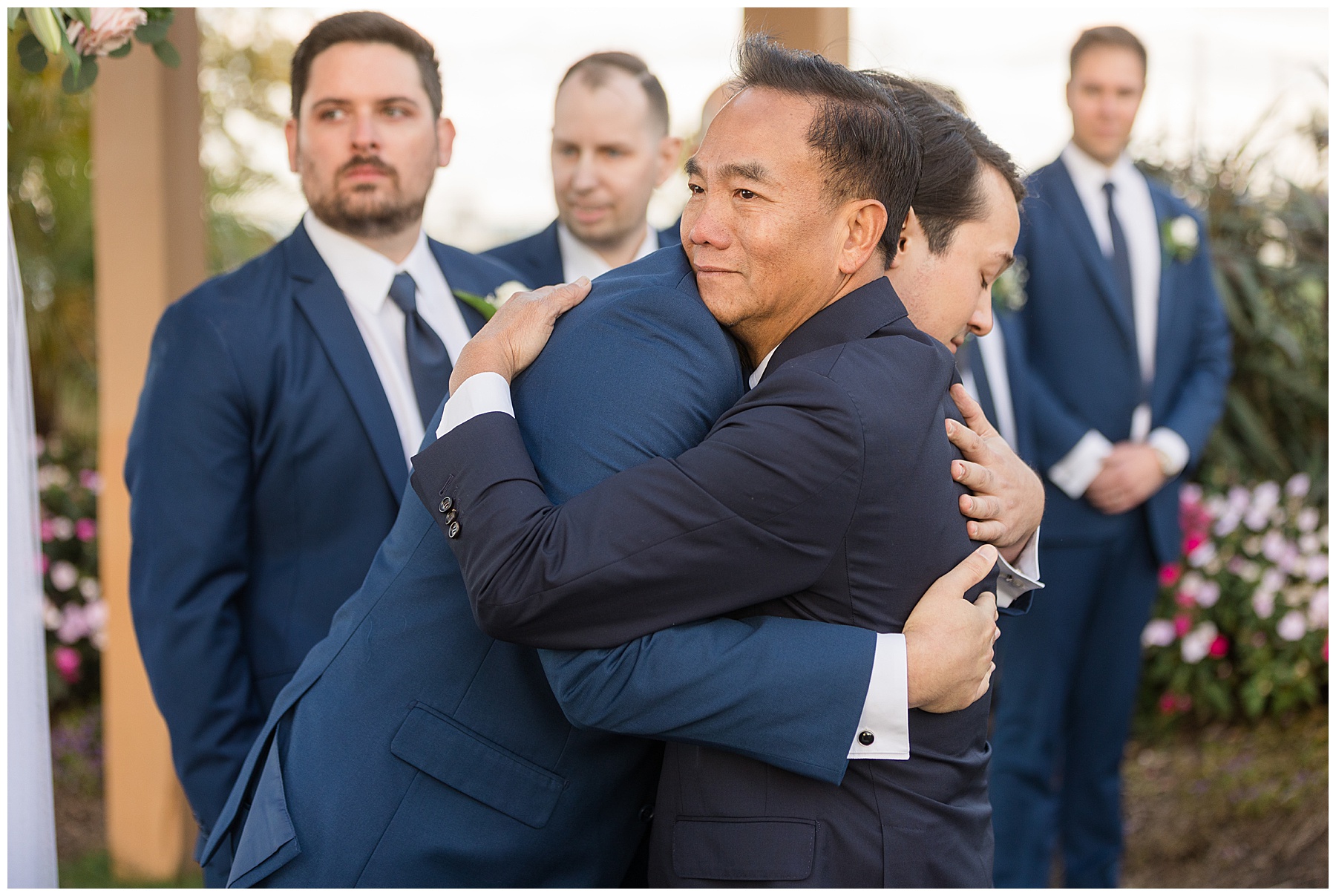 bride's dad hugging groom during ceremony