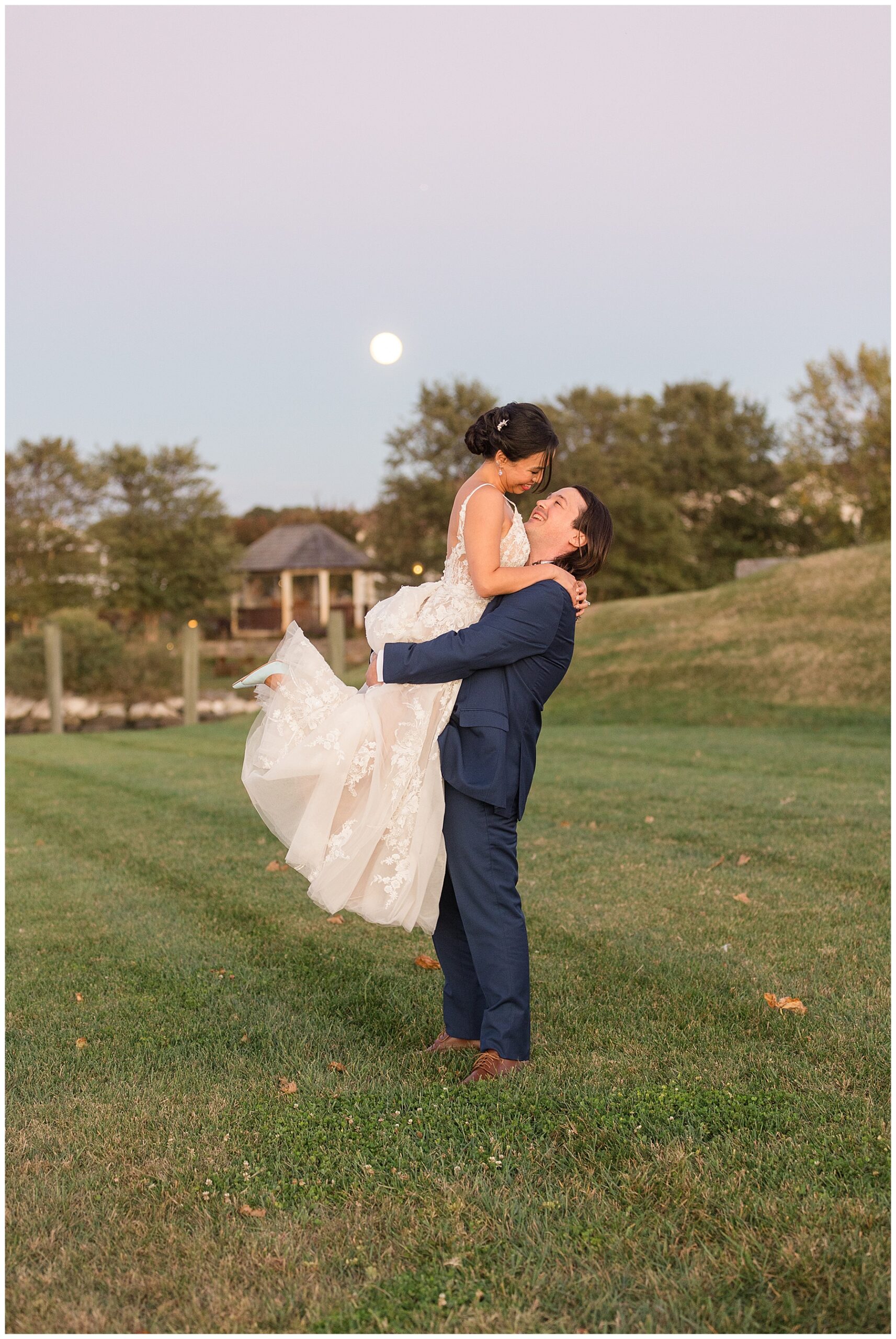 groom picks up bride sunset portrait with moon