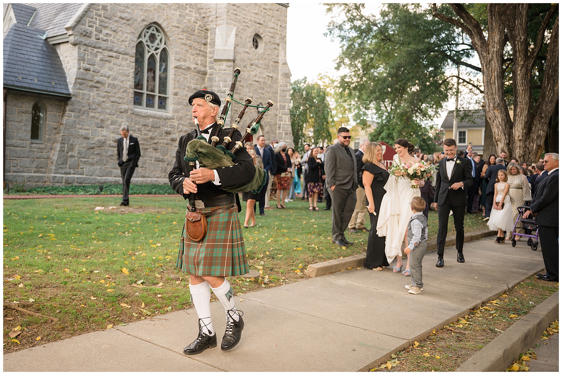 bride and groom celebrate with guests after ceremony and walk to reception with bagpipes