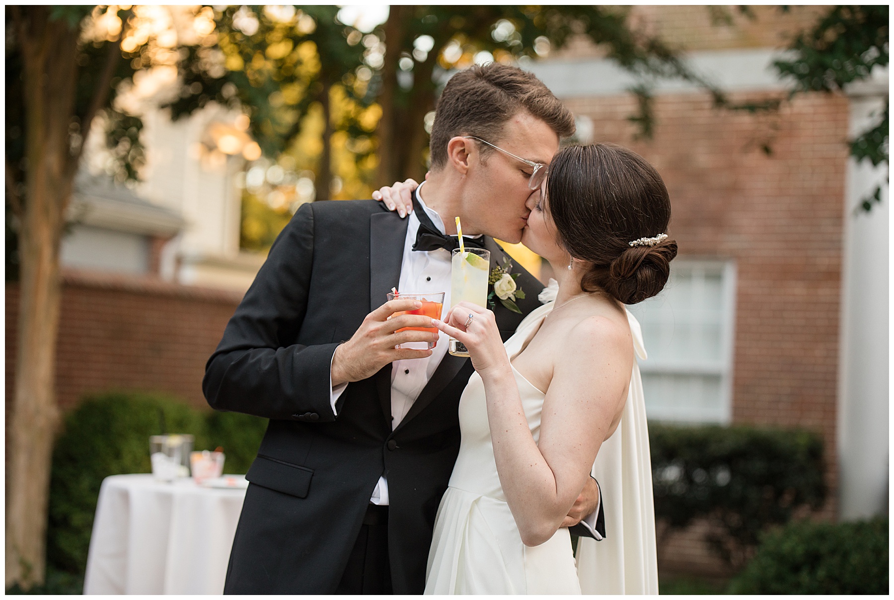 bride and groom kissing with signature cocktails