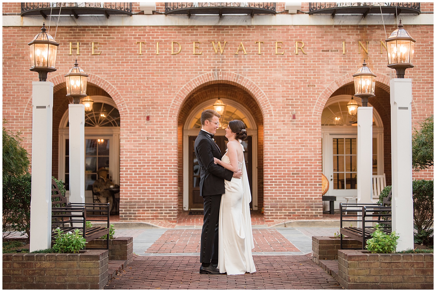 newlyweds smile at each other in front of venue tidewater inn