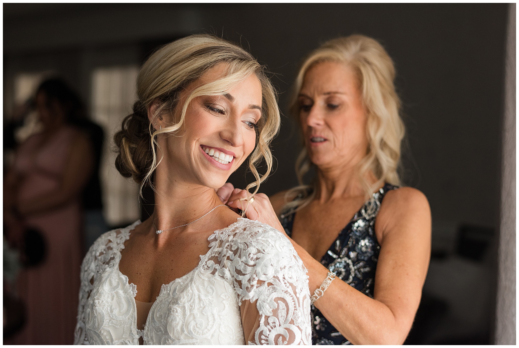 mother putting necklace on bride