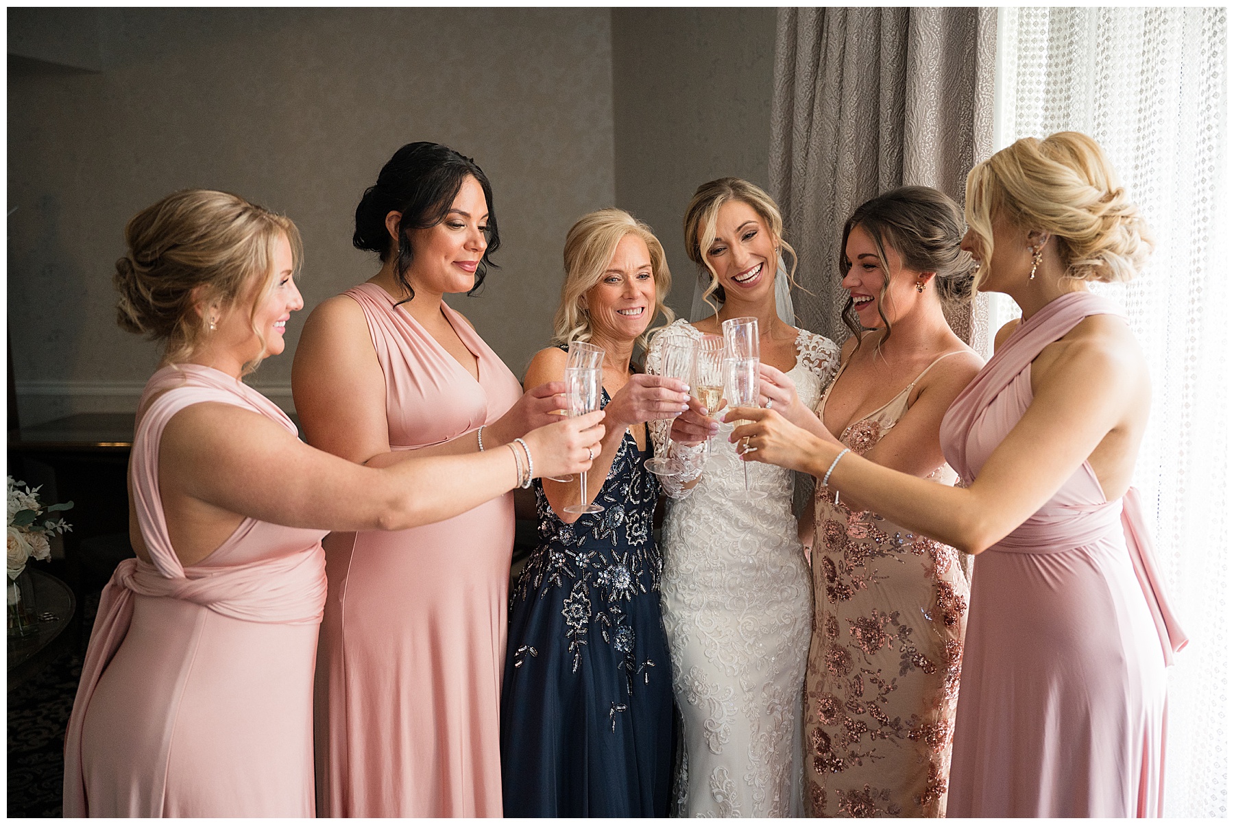 bride champagne cheers with bridesmaids