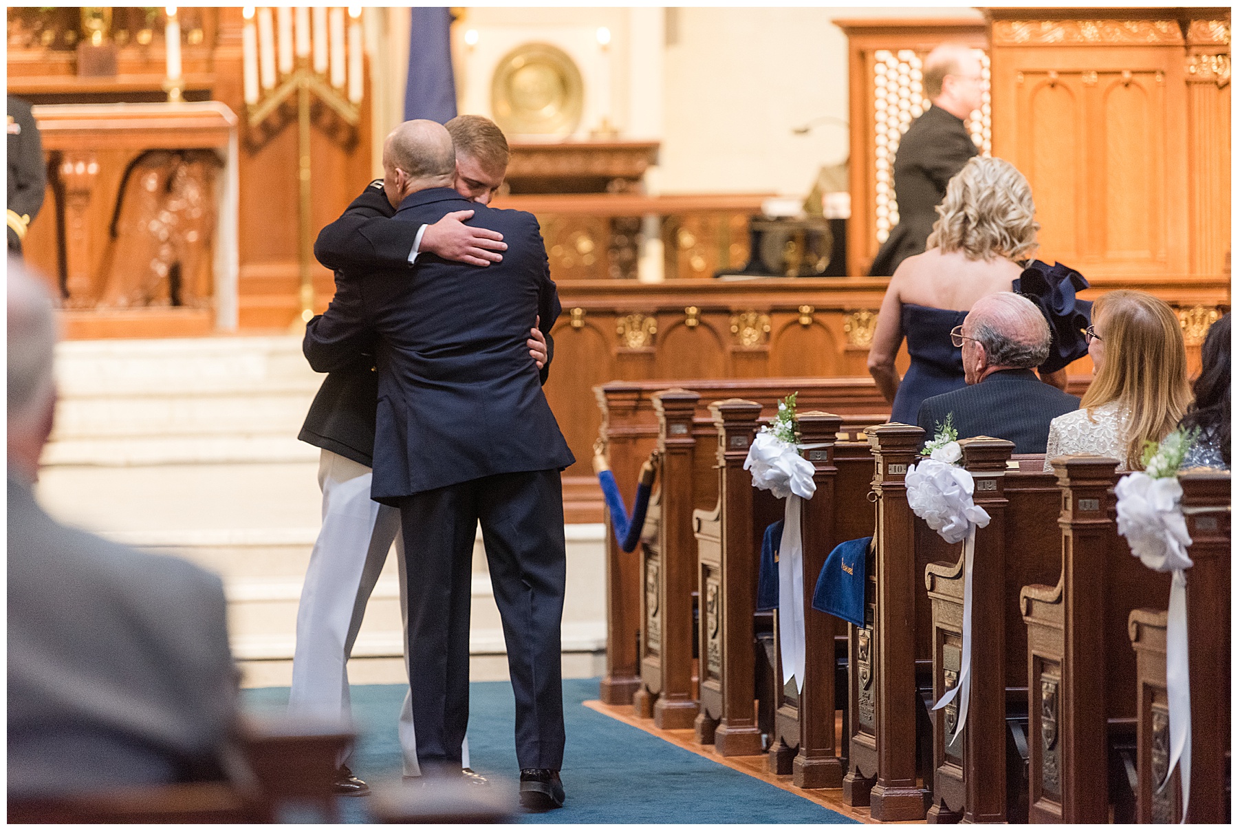 groom hugging dad at wedding ceremony usna chapel