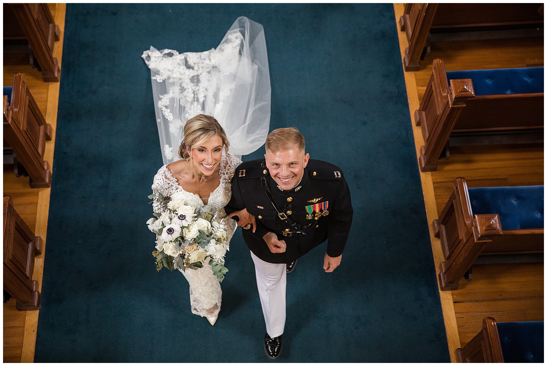 wedding ceremony at usna chapel bride and groom look up to balcony