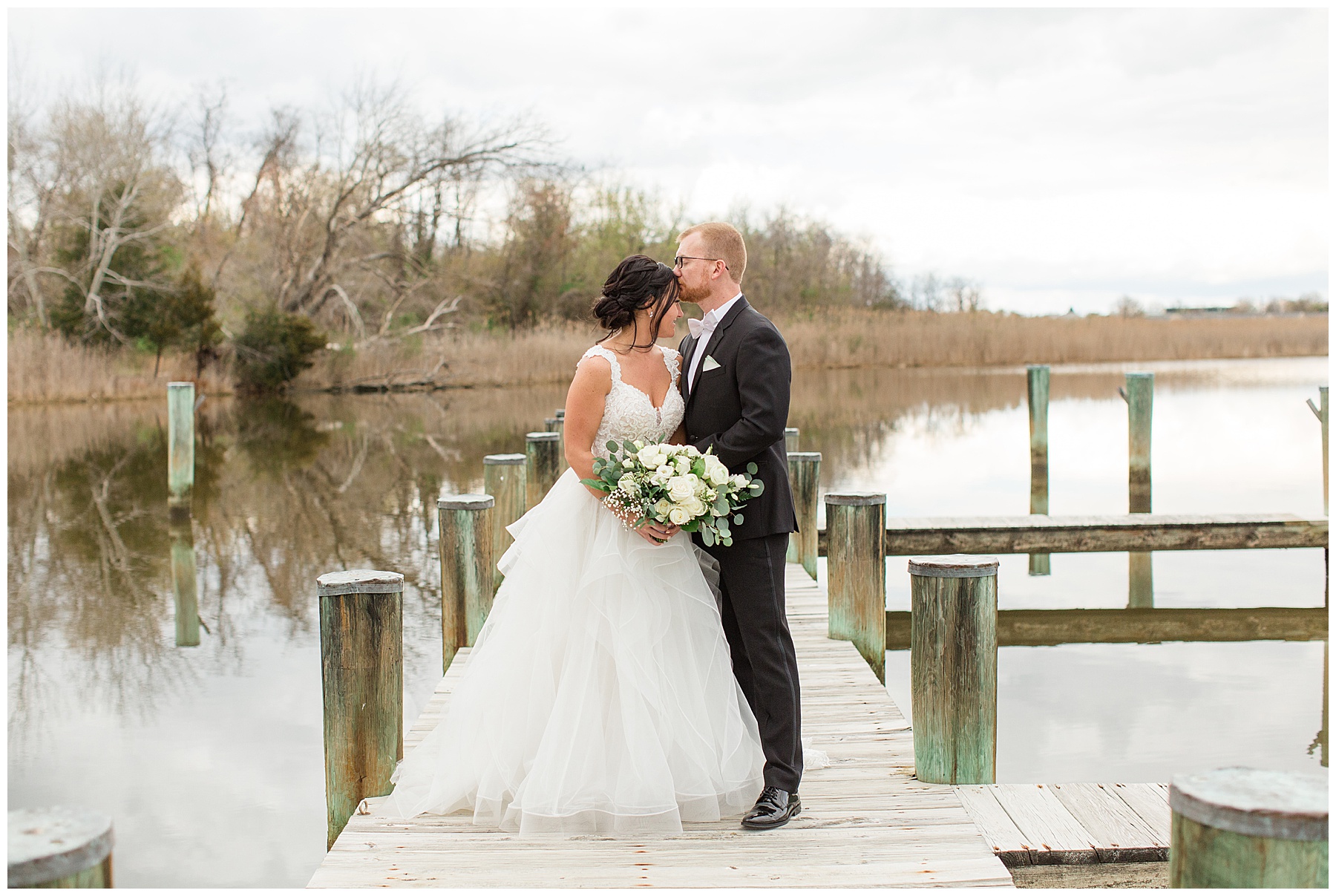 bride and groom embrace on kent island pier