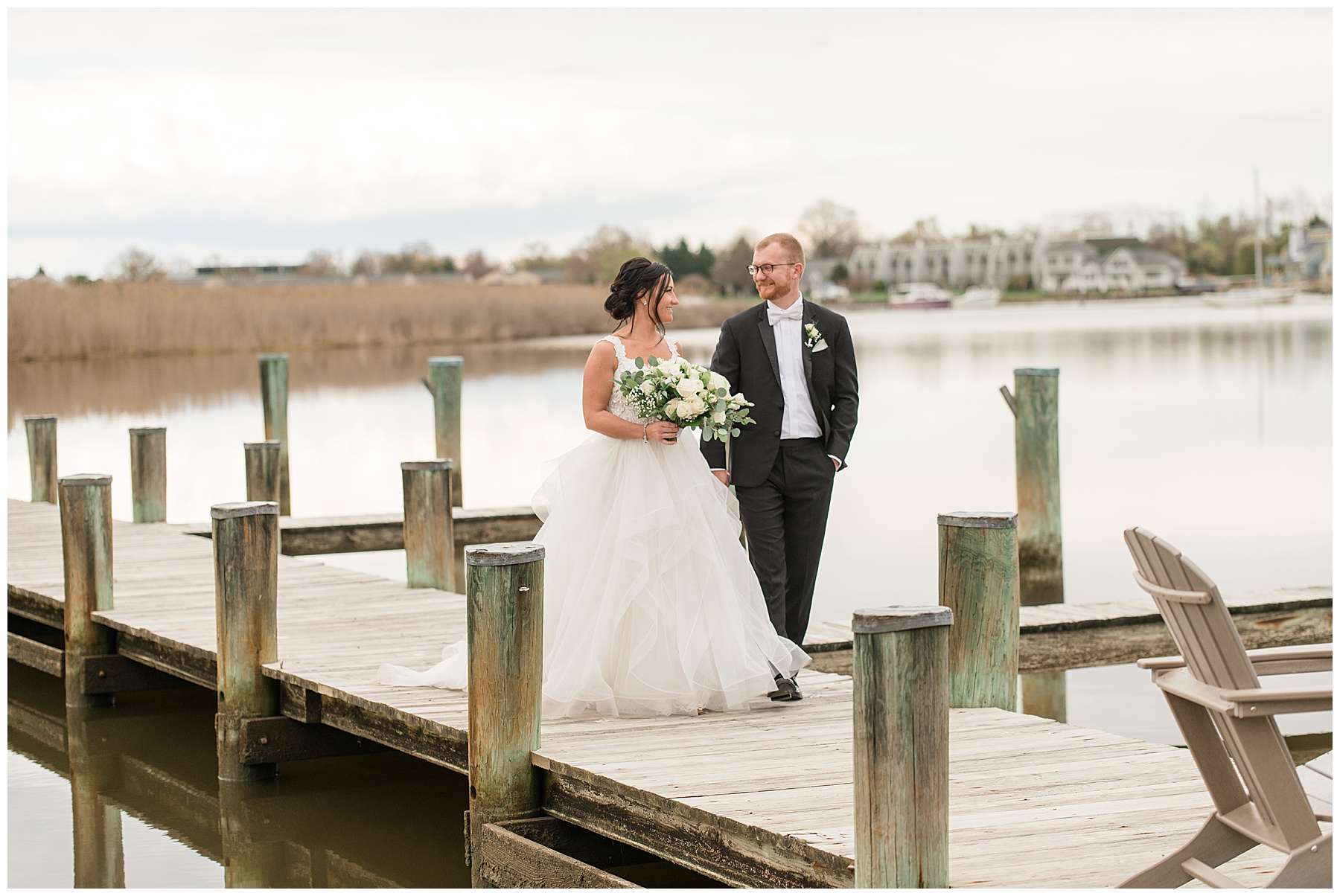 bride and groom embrace on kent island pier