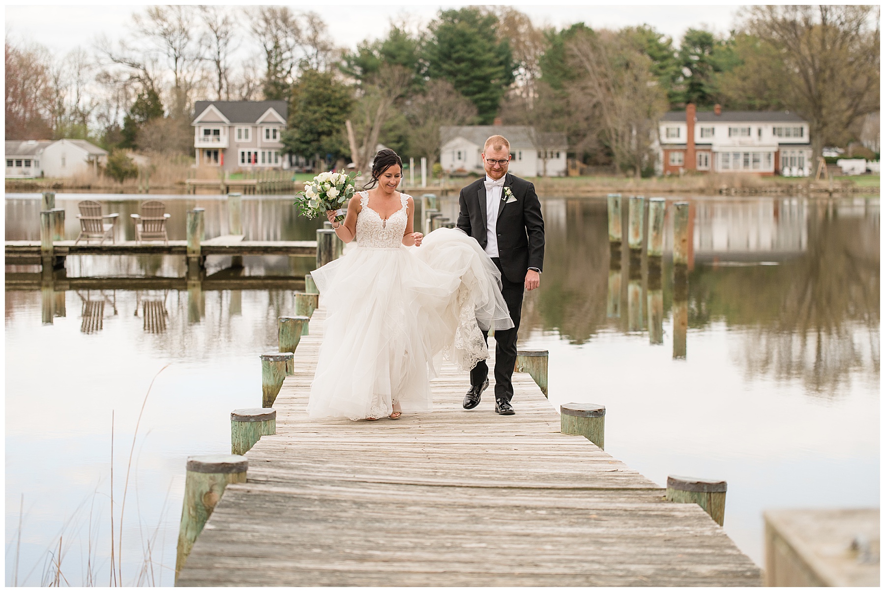 bride and groom embrace on kent island pier