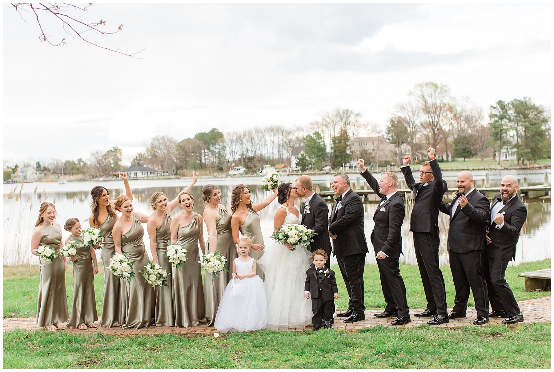 wedding party cheer as bride and groom kiss