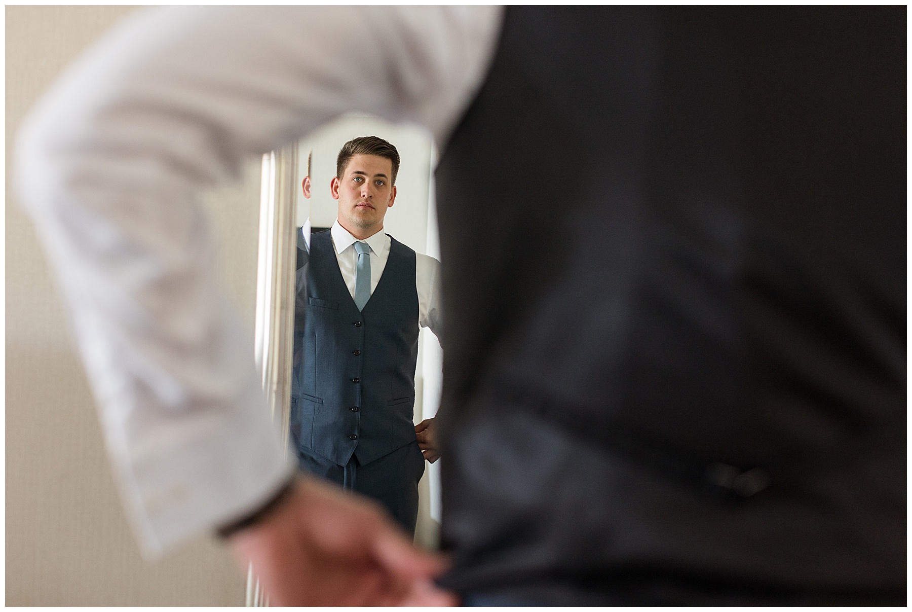 groom getting ready looking in mirror