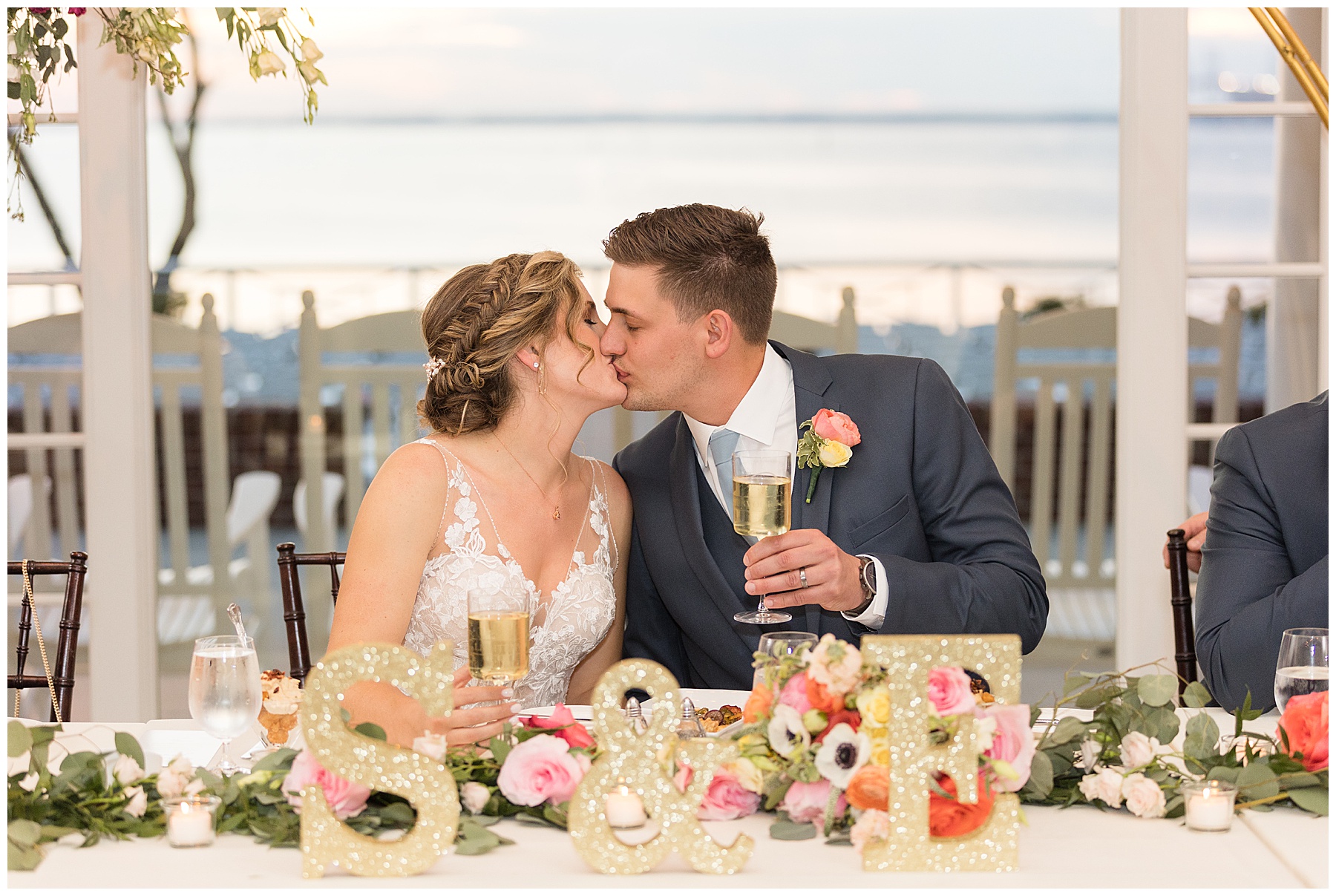 bride and groom kiss at head table