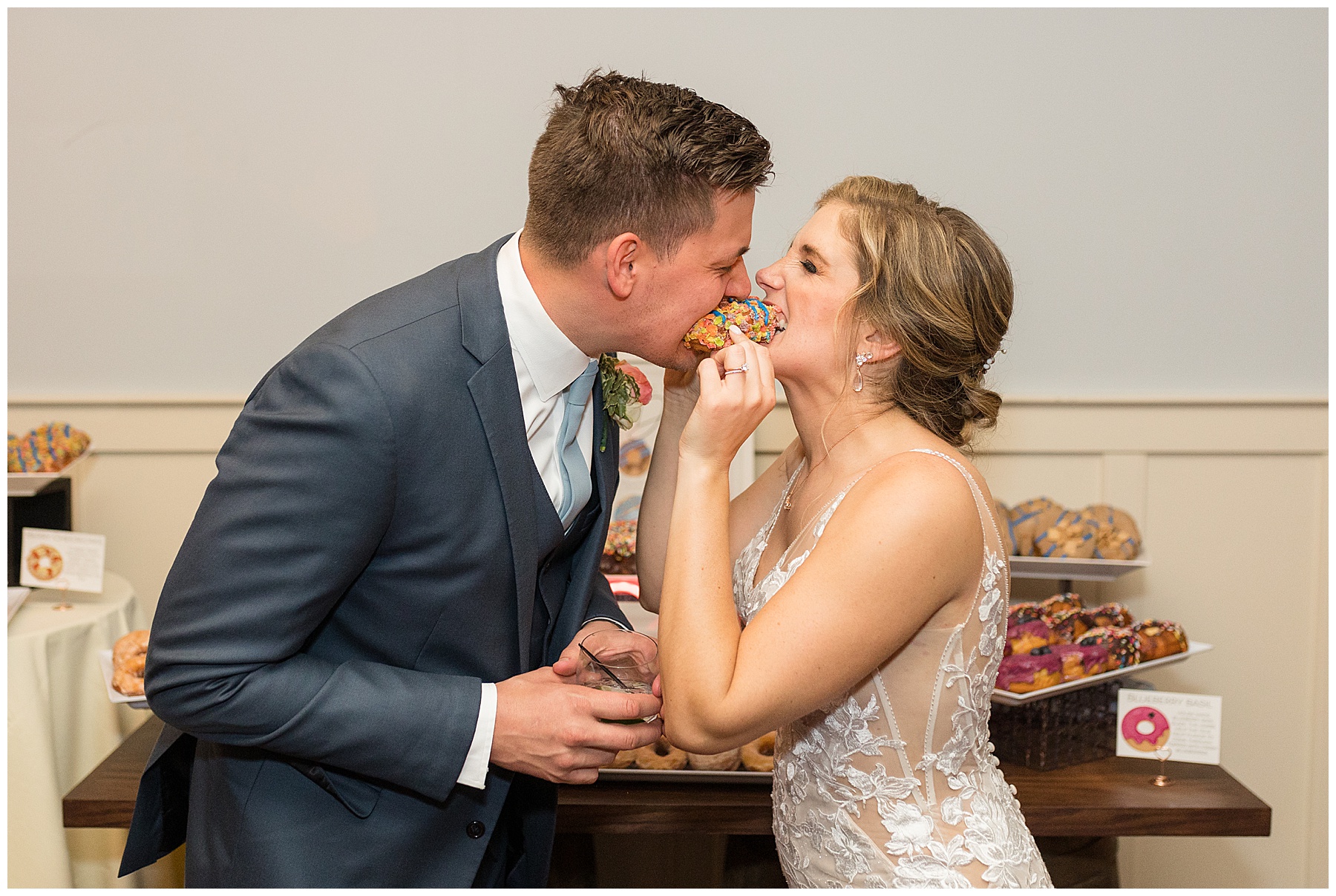 bride and groom share donut