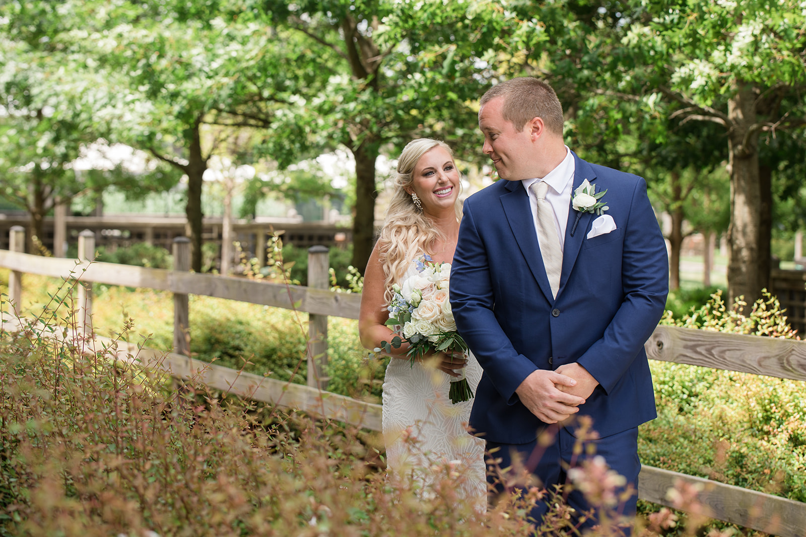 bride tapping groom on shoulder for first look