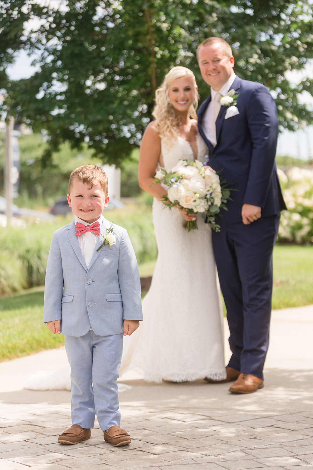 bride and groom in the background with son in focus in foreground