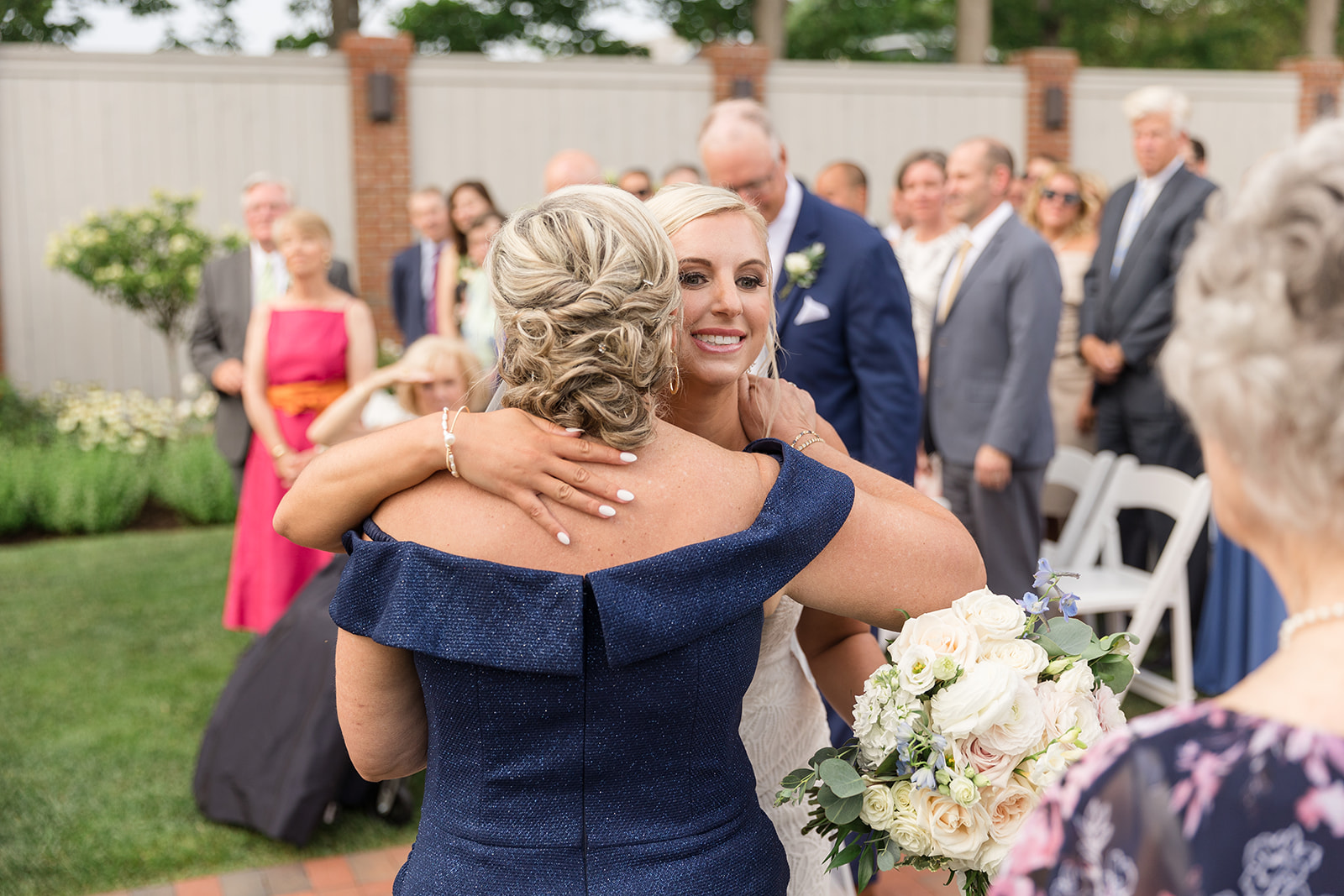 bride hugs her mom at end of aisle