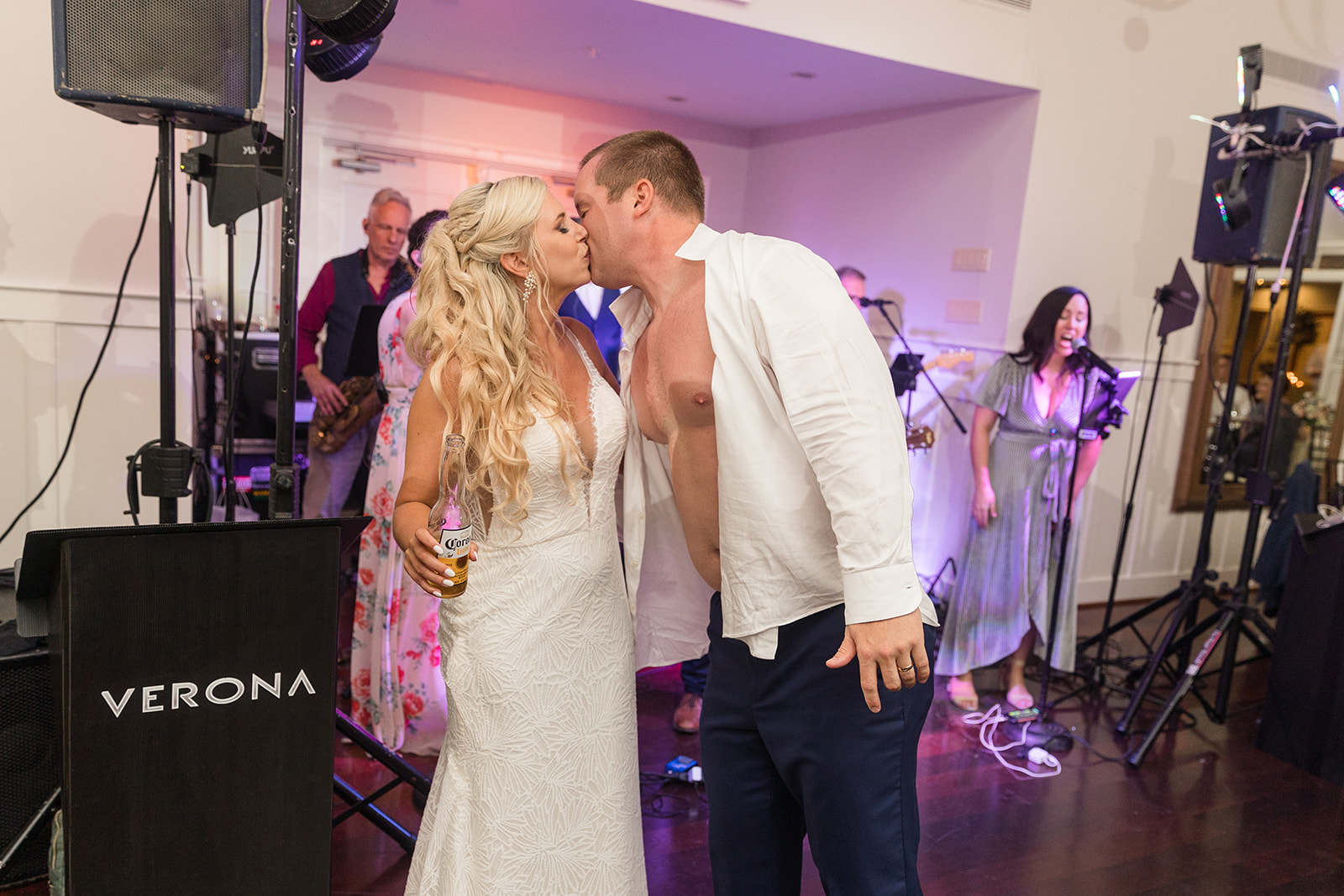 candid dancing during wedding reception groom takes shirt off