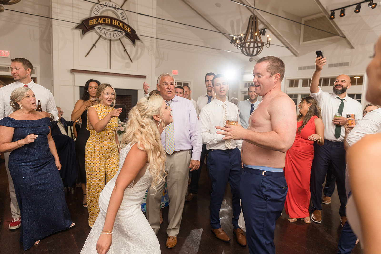 candid dancing during wedding reception groom without shirt