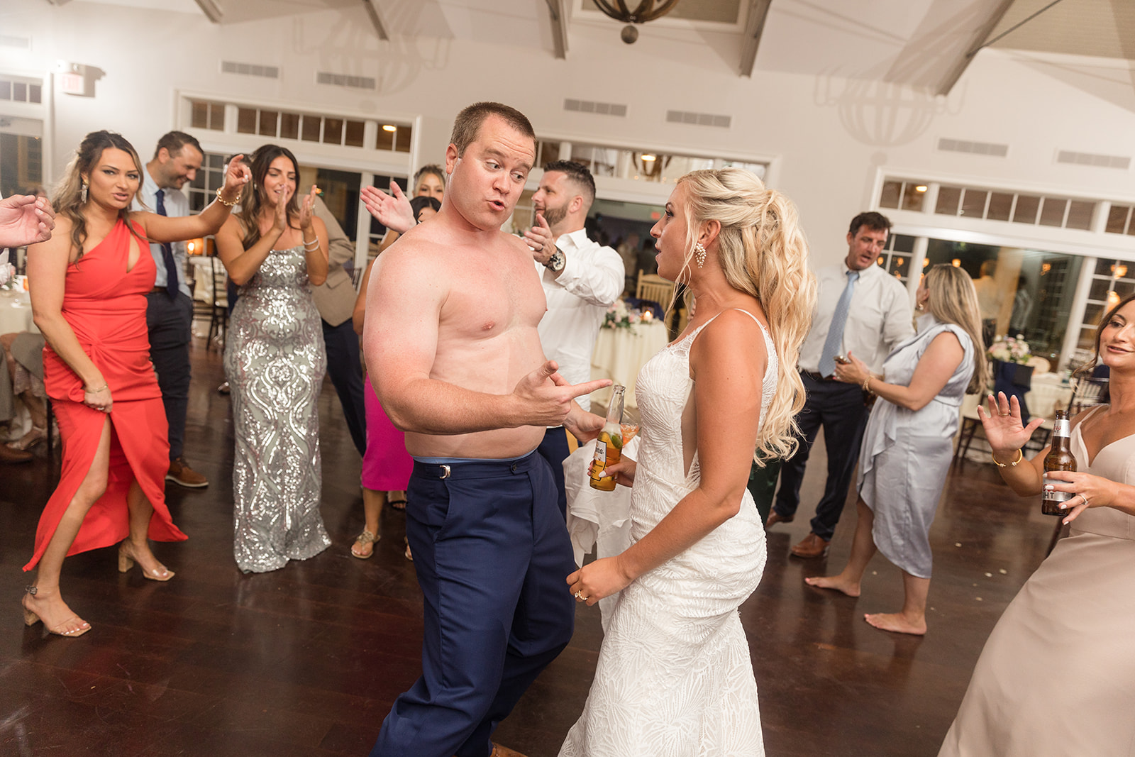 candid dancing during wedding reception groom without shirt