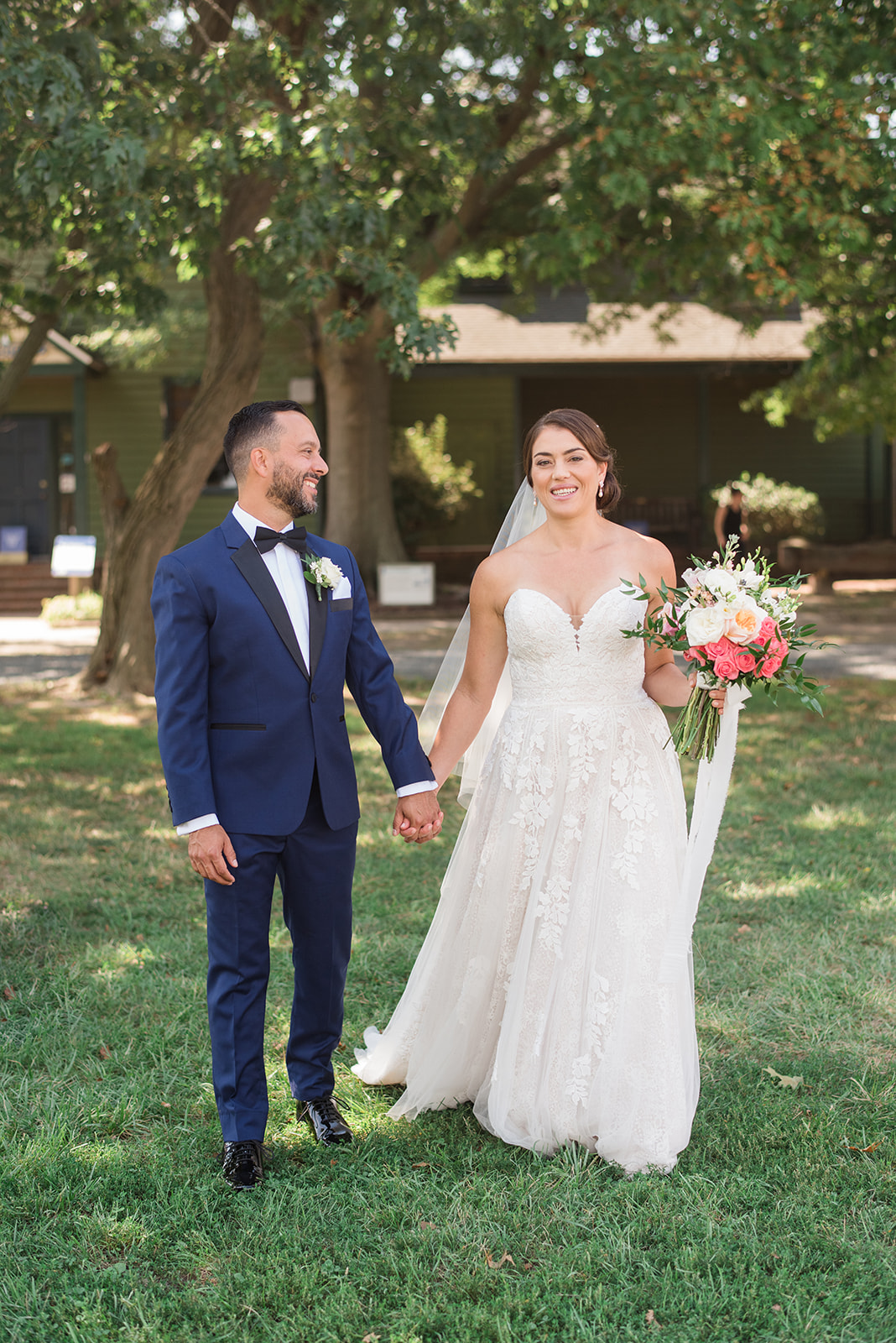 bride and groom walking holding hands with bridal bouquet