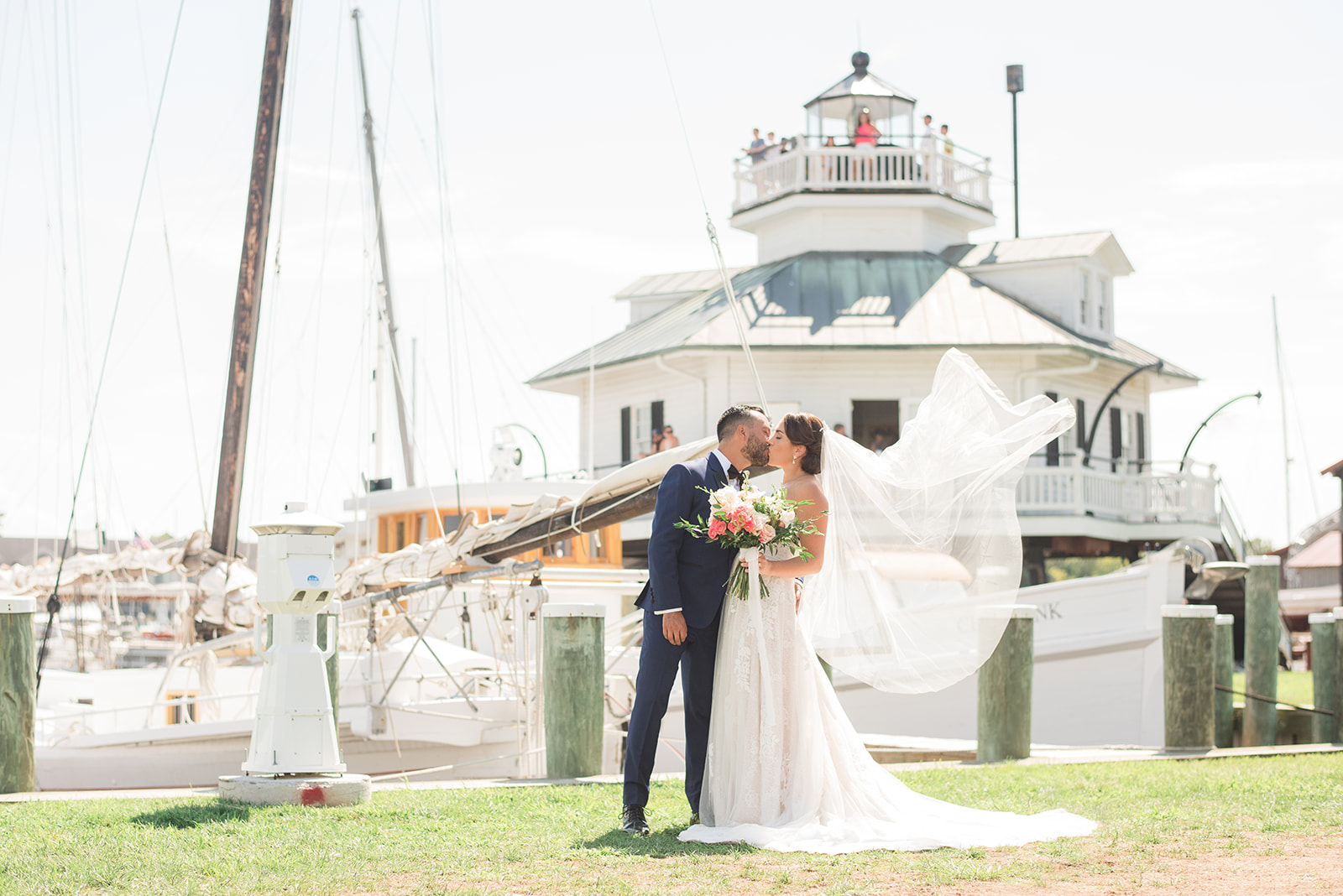 bride and groom kissing veil blwoing st michaels maritime museum