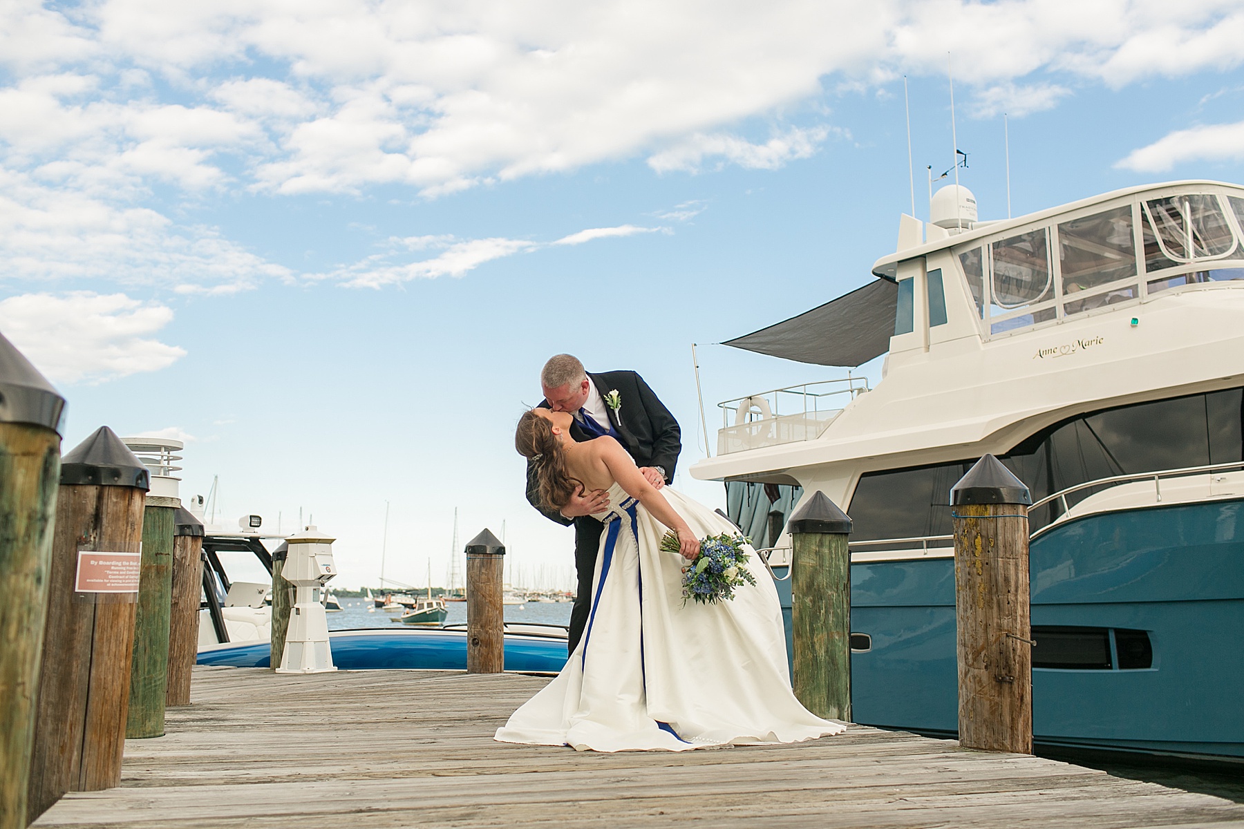 bride and groom kiss on pier