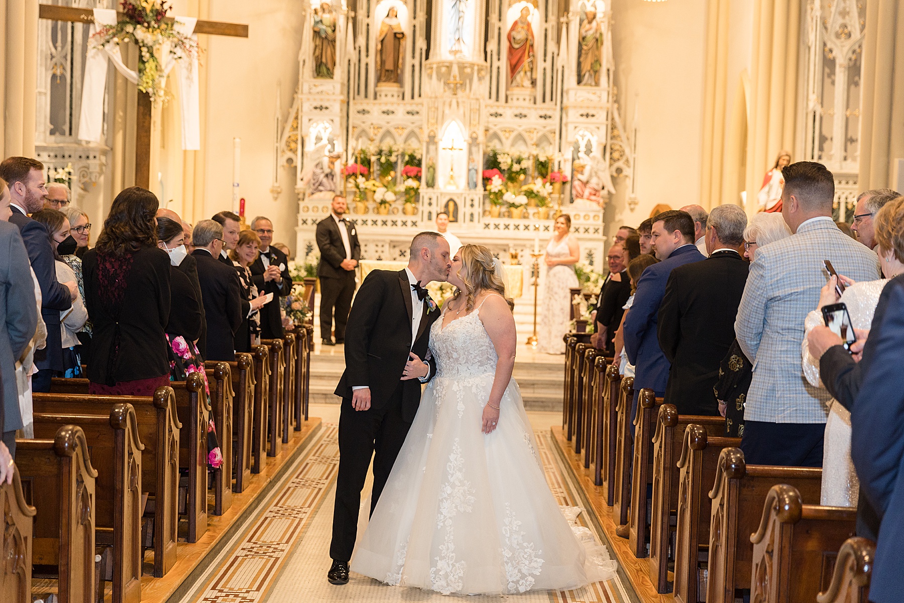 bride and groom kiss in church aisle