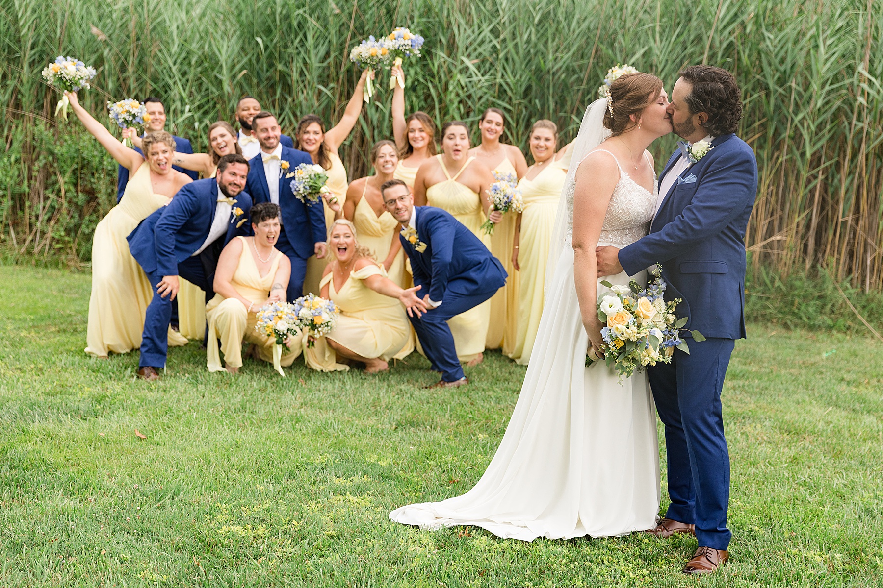 wedding party cheering bride and groom kissing