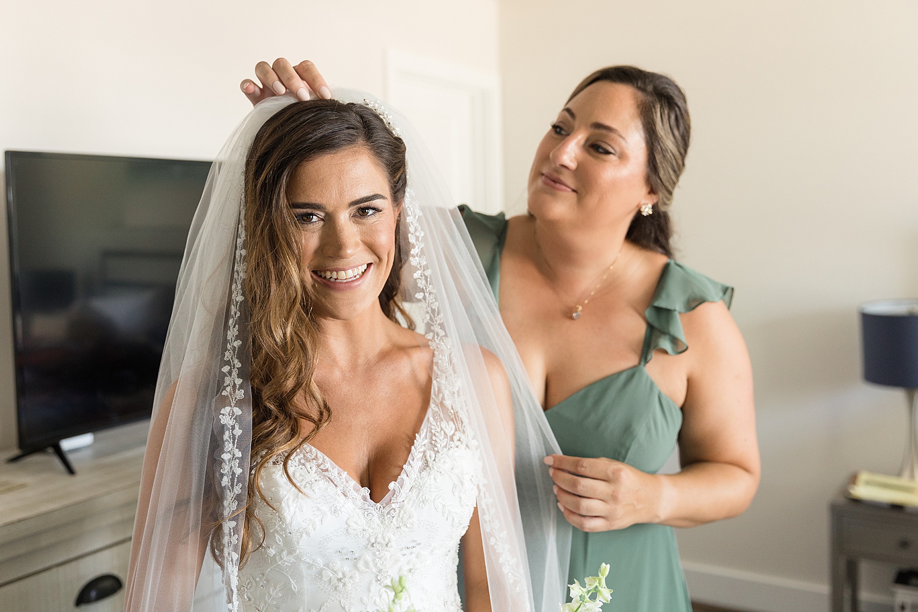 maid of honor puts veil in bride's hair