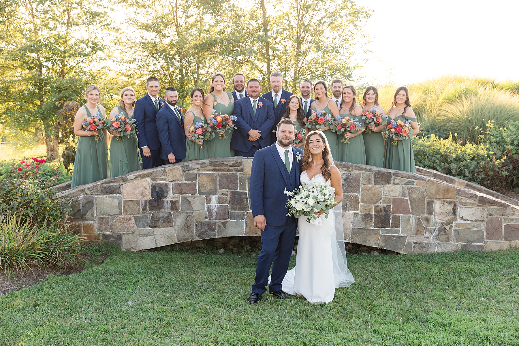 couple with full wedding party green and navy