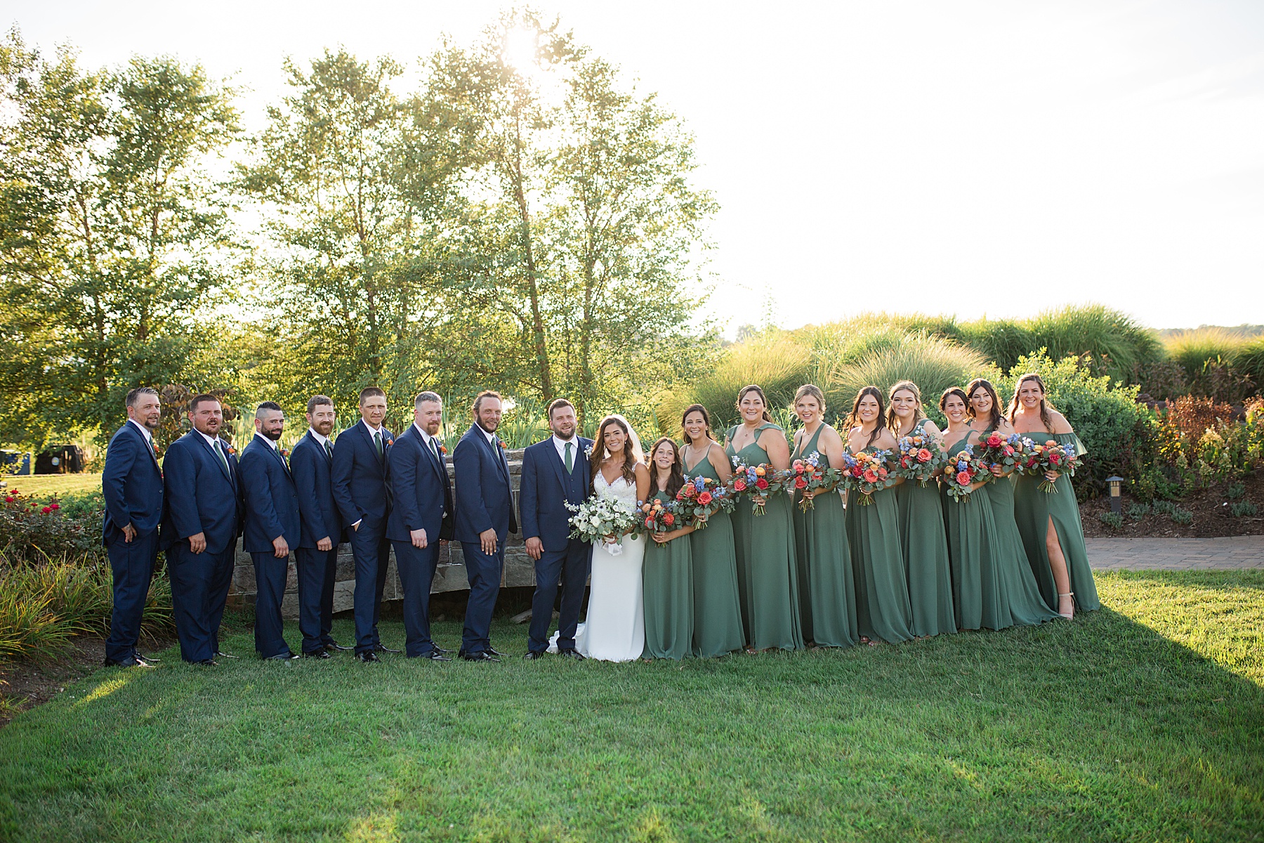 couple with full wedding party green and navy