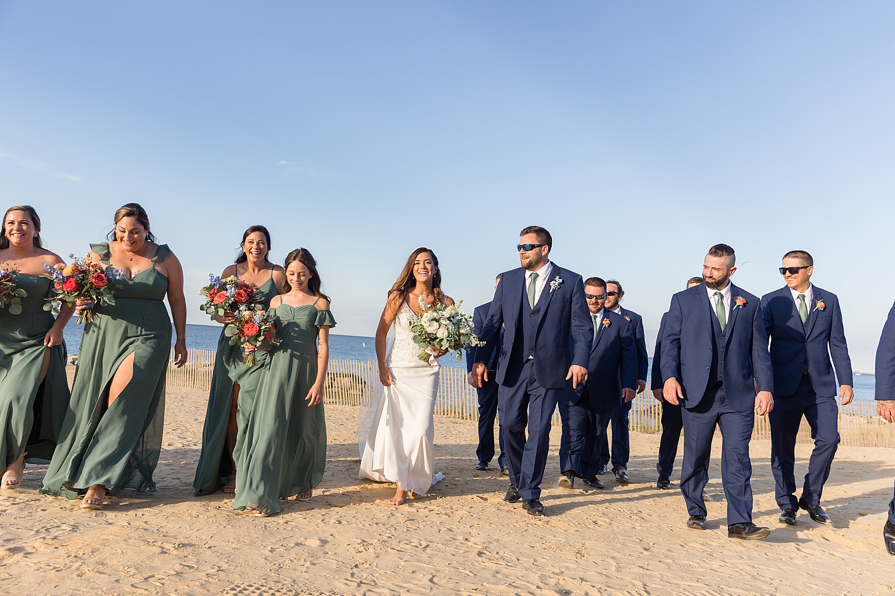 couple with full wedding party green and navy beachy