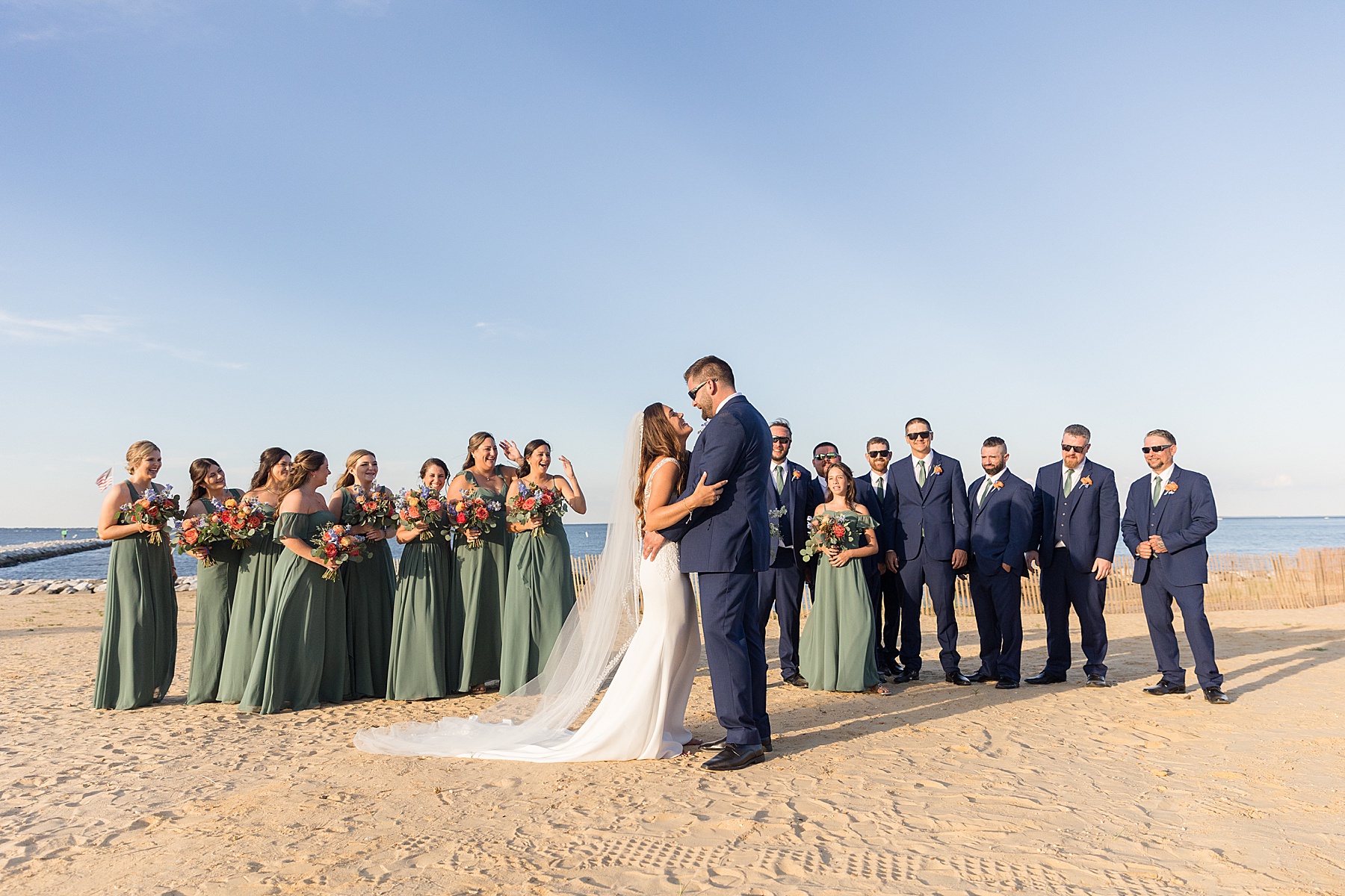 couple with full wedding party green and navy beachy