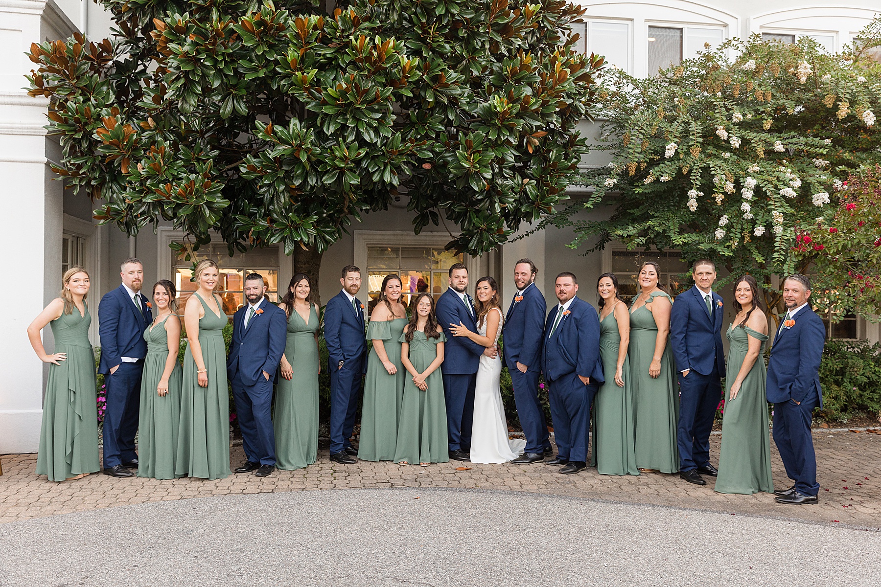 couple with full wedding party green and navy