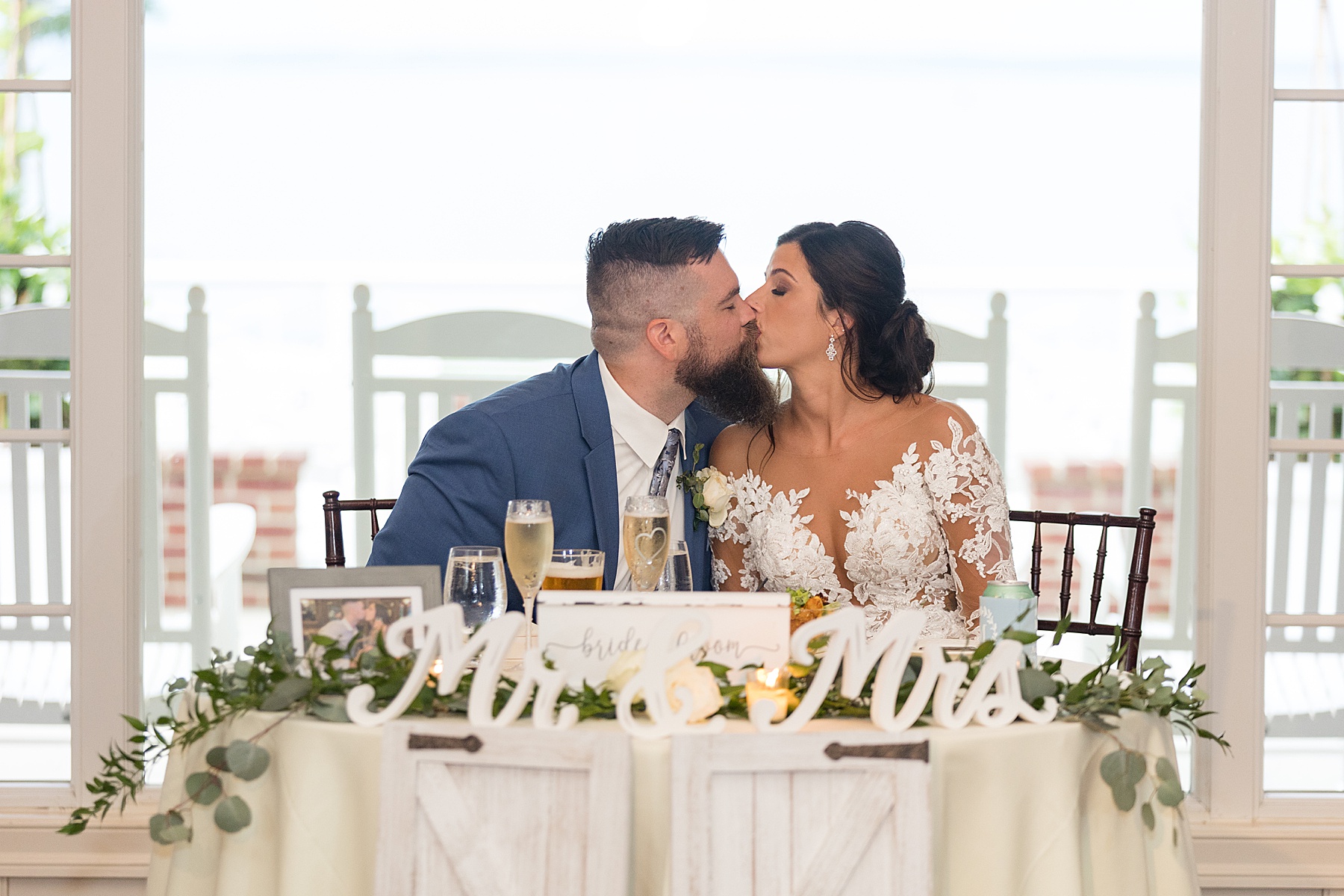 bride and groom kiss at sweetheart table