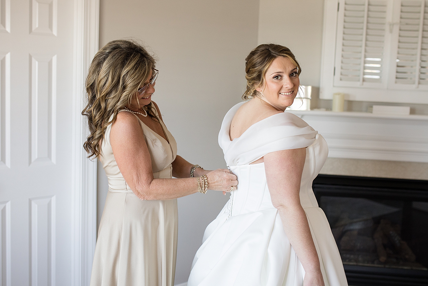 bride getting dressed with mom