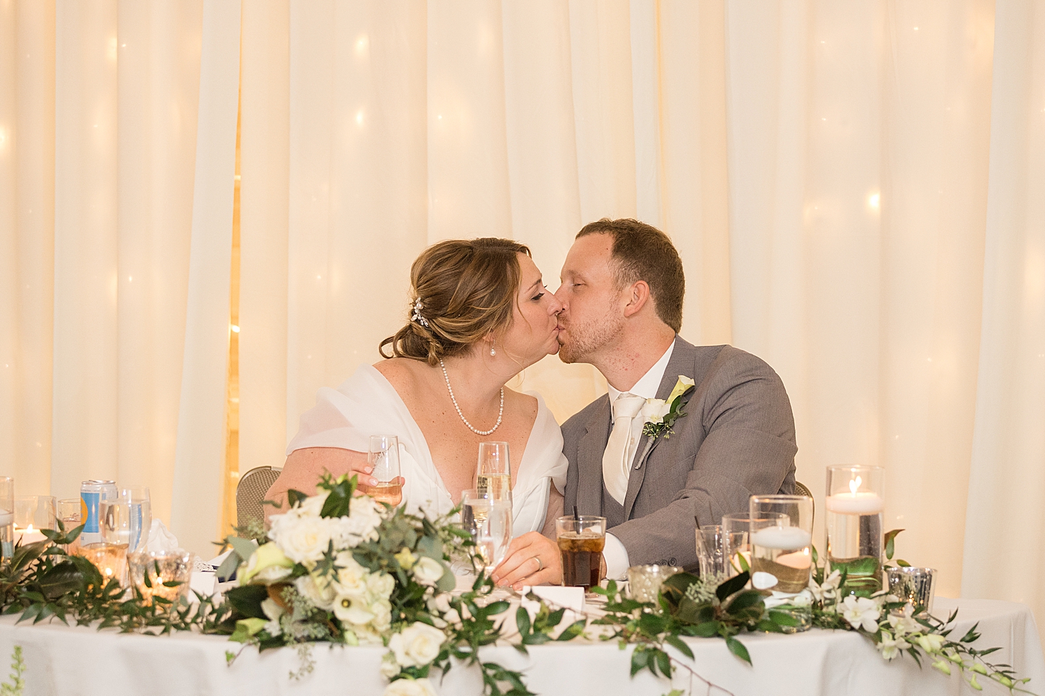 bride and groom kiss at sweetheart table